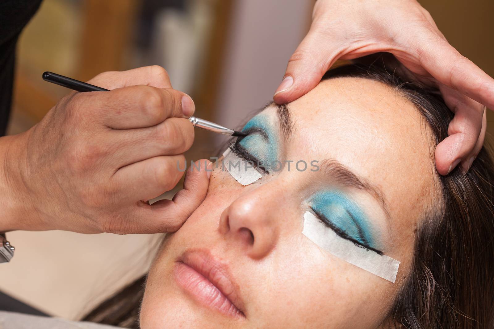 Make up artist creating cat eyes on a white woman