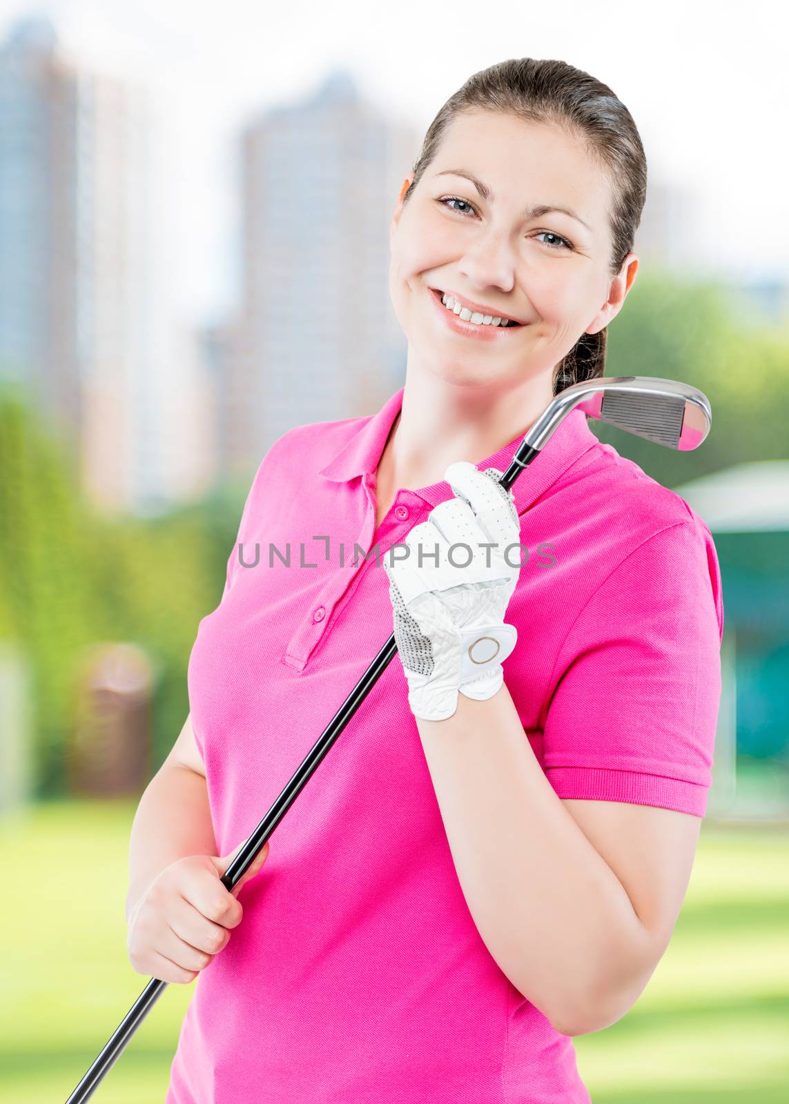 happy golfer on a background of golf courses smiling and holding a golf club