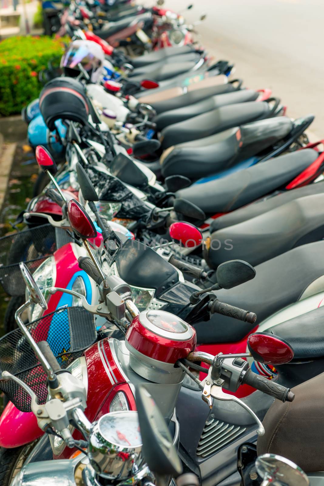 moped parked at the pavement in a row in Thailand