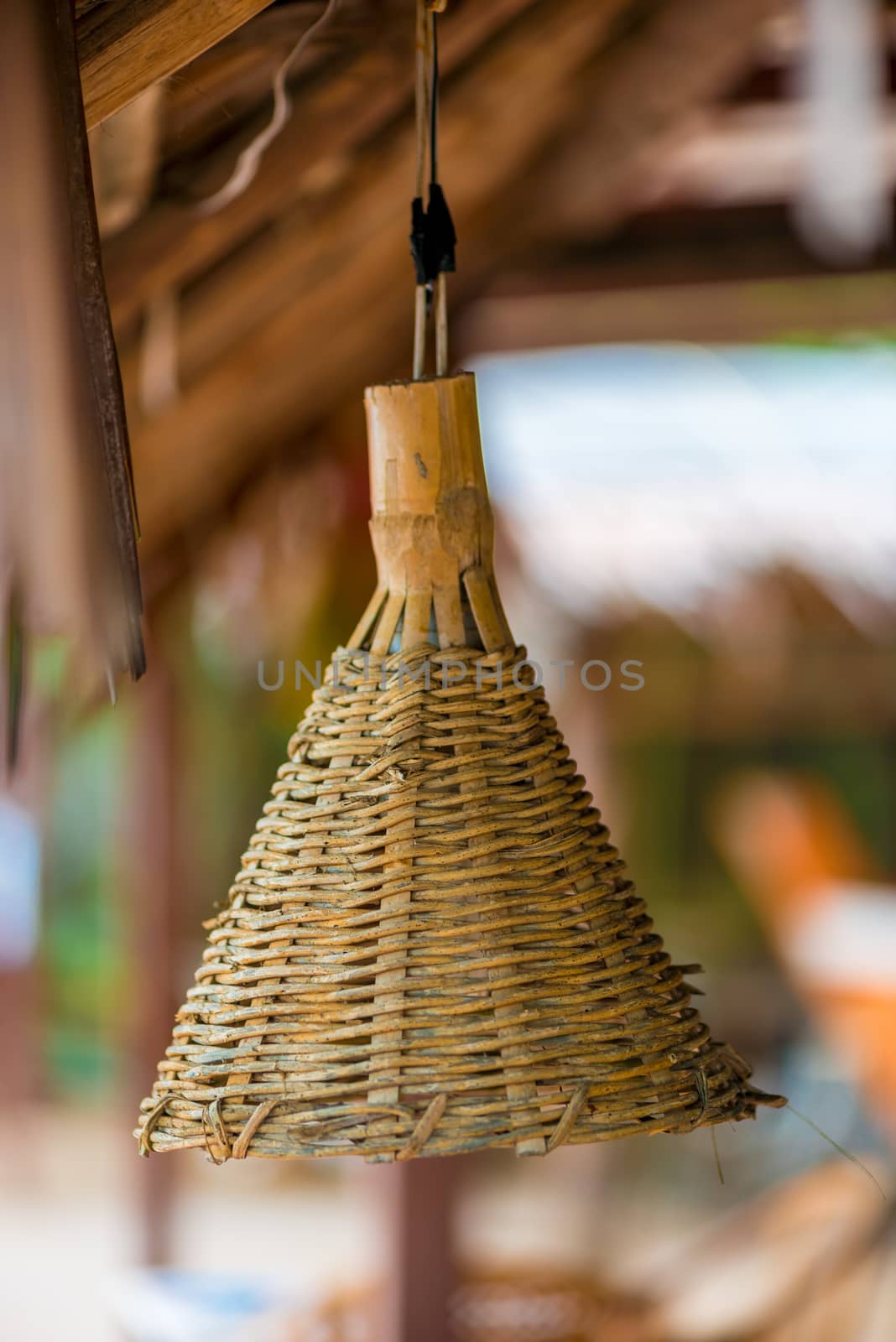 A woven straw shade for a lamp hanging on the ceiling