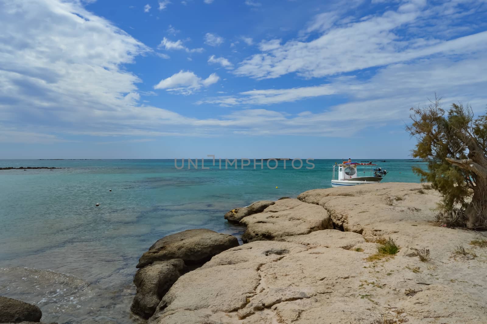 View From the sandy beach of Elafonisi with a small fishing boat in the west of the island of Crete