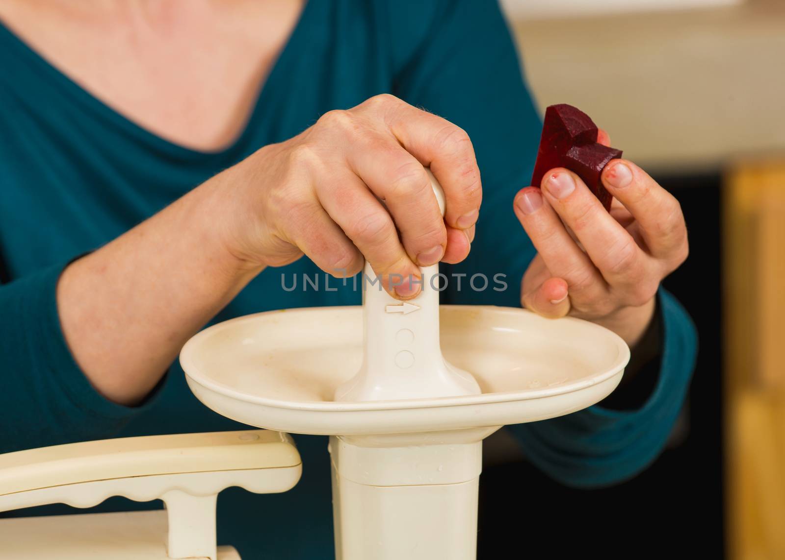 Woman using a centrifuge machine to prepare a detox juice. 