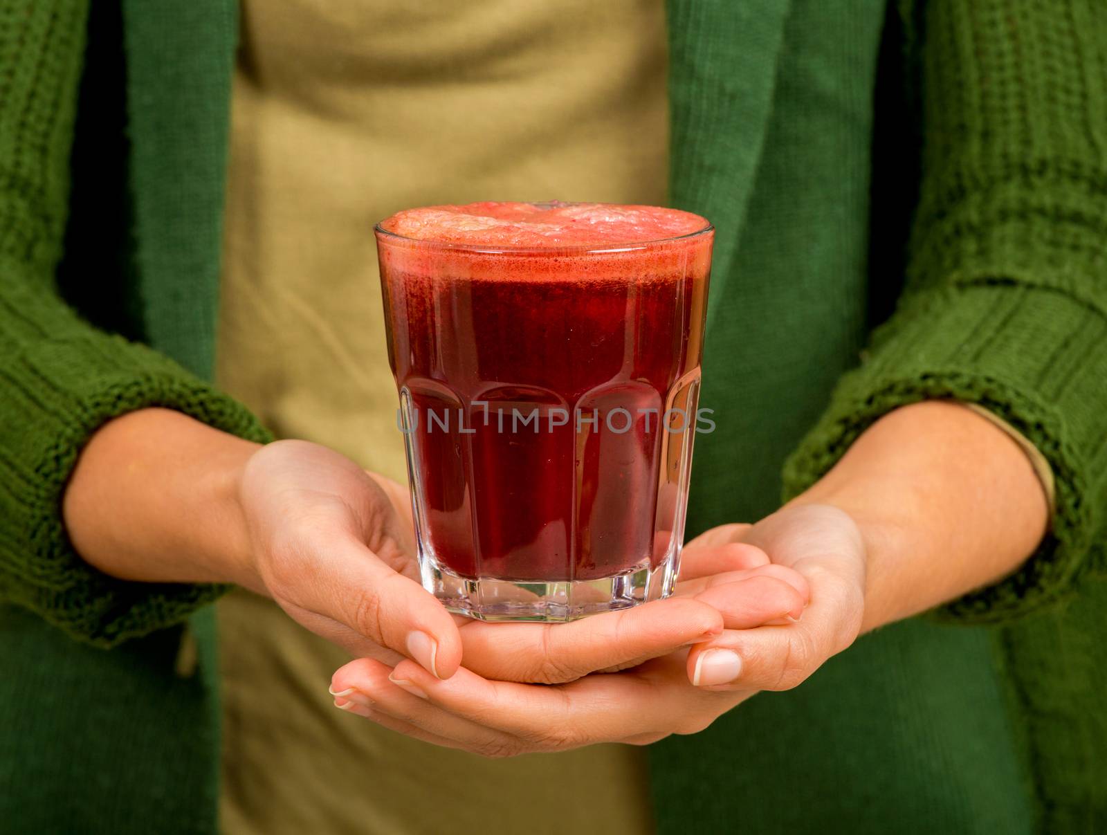 Woman holding a glass of red juice. Preparing a detox juice.  