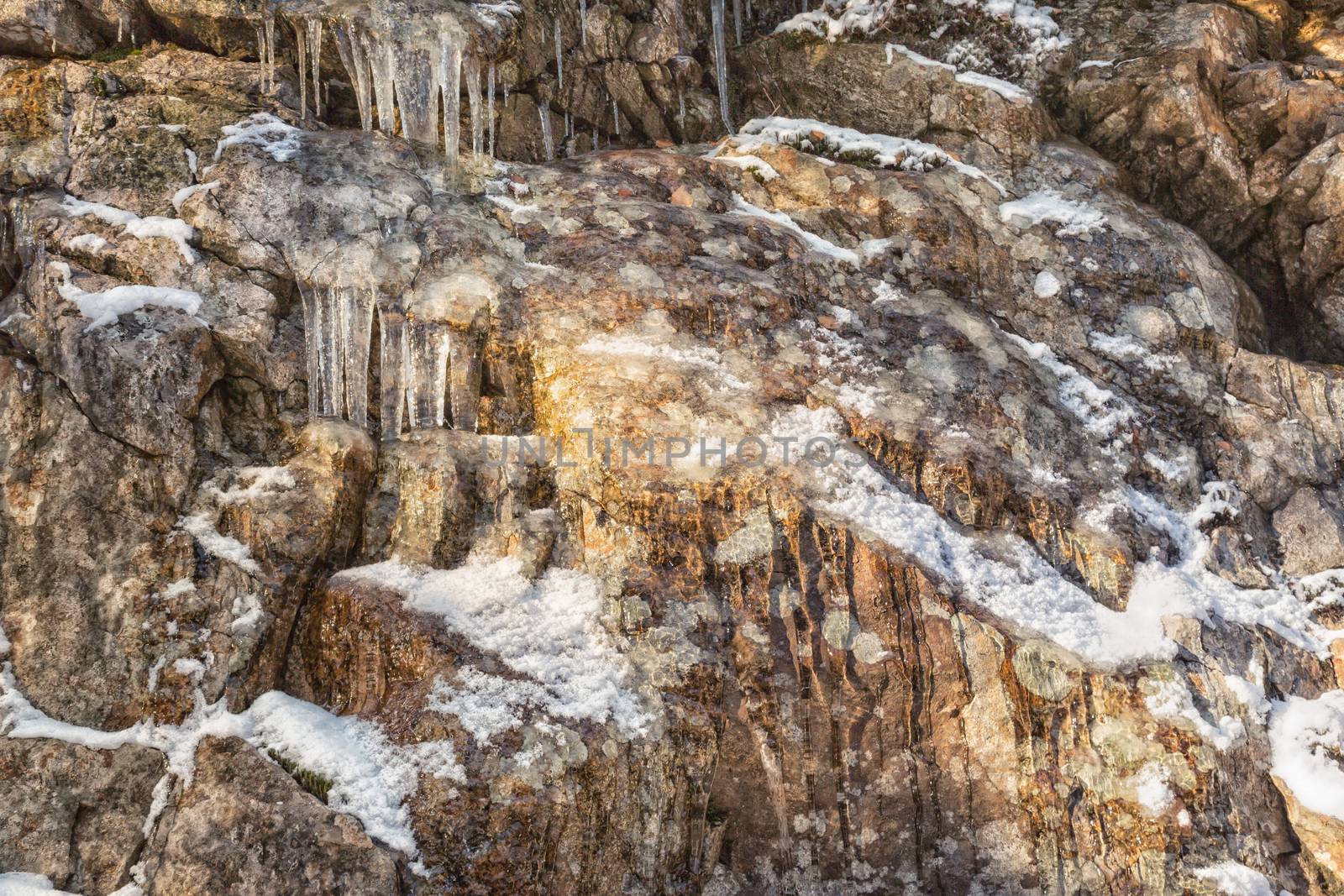 Many small icicles on a stone wall by sandra_fotodesign