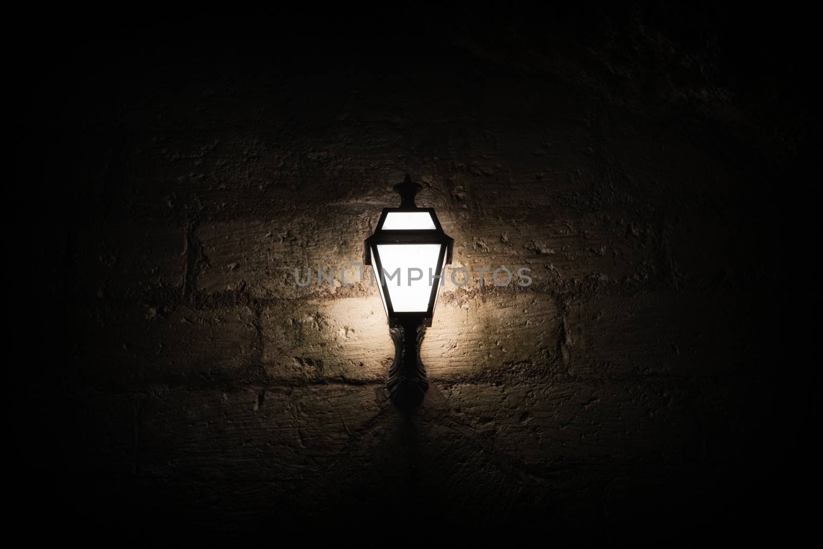 A luminous lantern on a stone wall