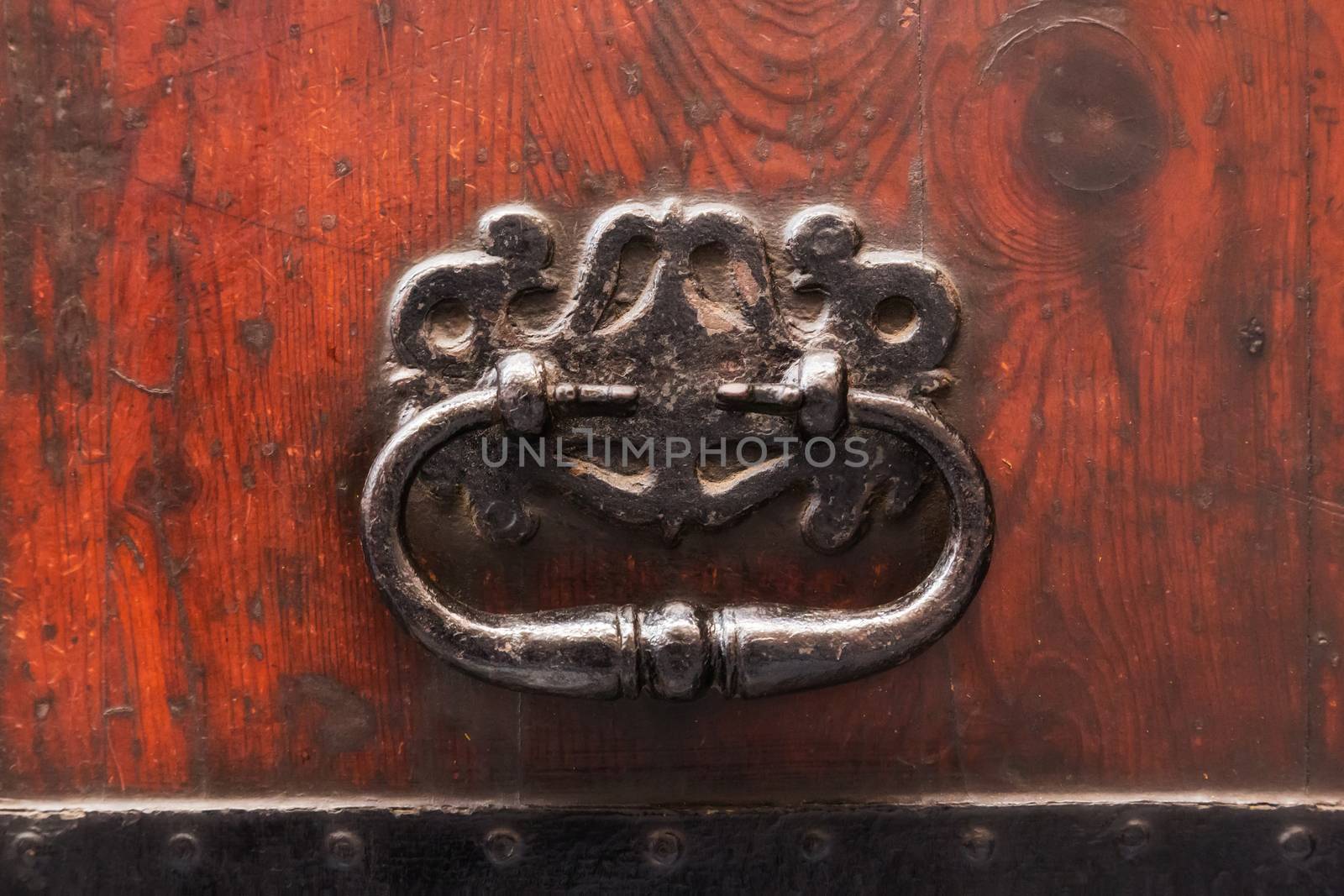A door knocker made of brass on a wooden door