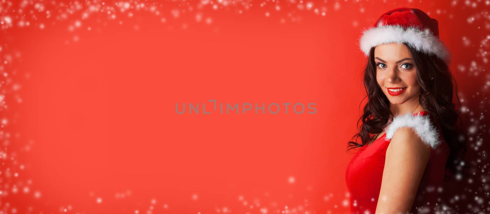 Pretty Pin-up style Santa girl in red hat on red background