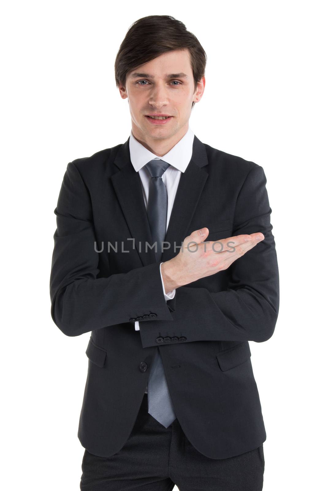 Portrait of young business man in black suit pointing on something with hand isolated on white background
