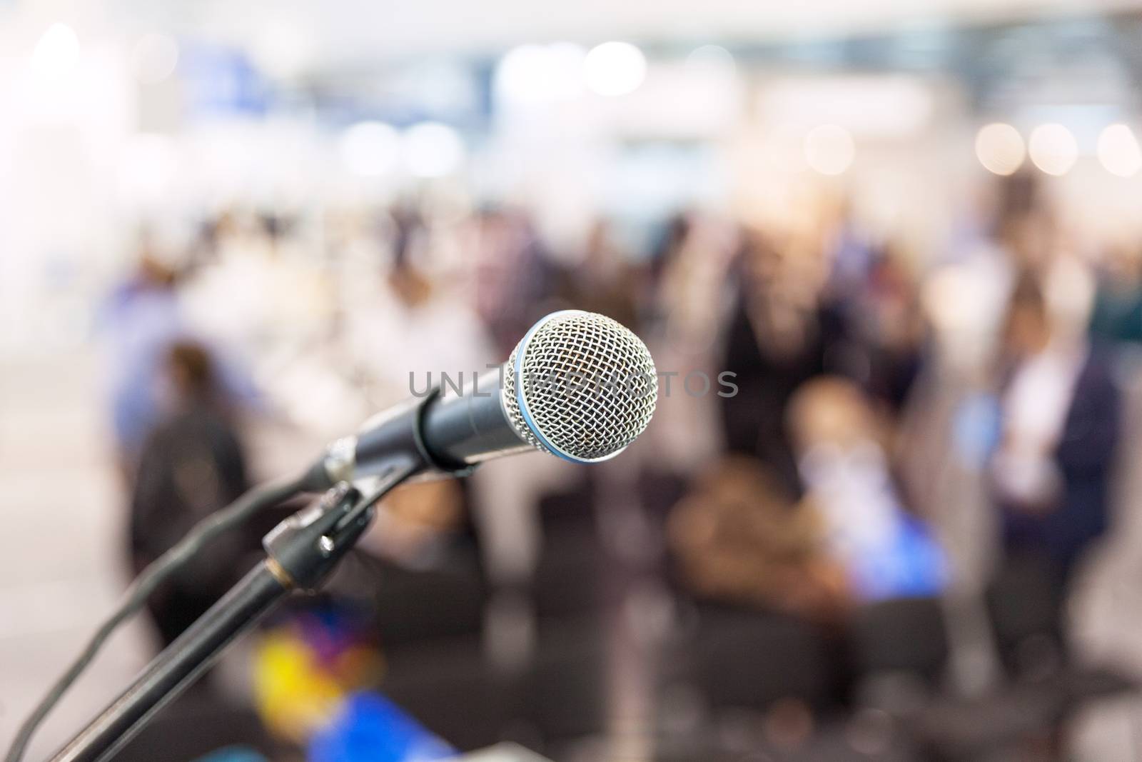 Microphone in focus against blurred audience. News conference. by wellphoto