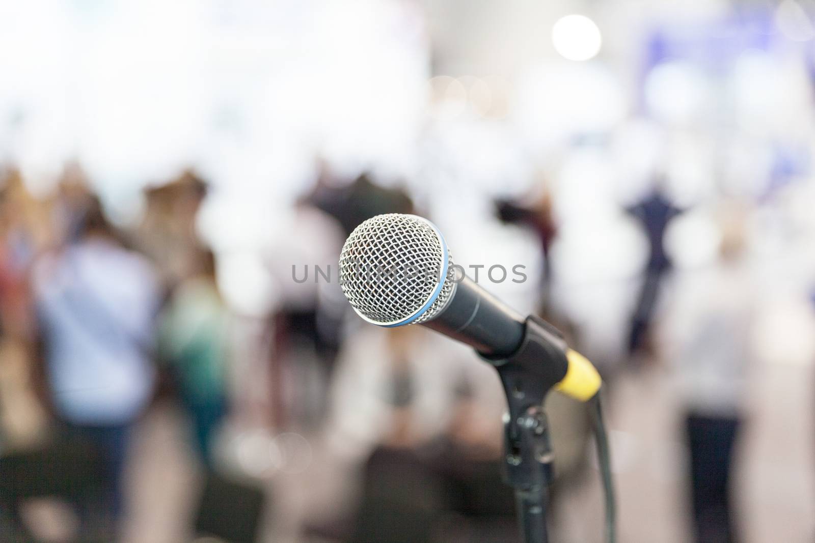 Microphone in focus against blurred audience. Press conference. by wellphoto