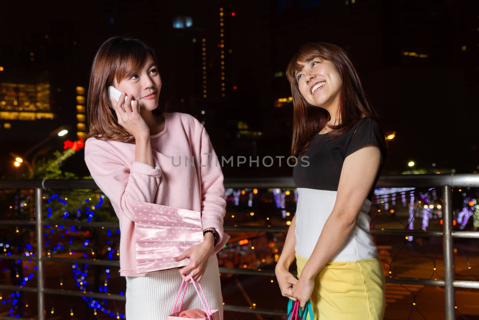 Chinese and Japanese women shopping in city at night