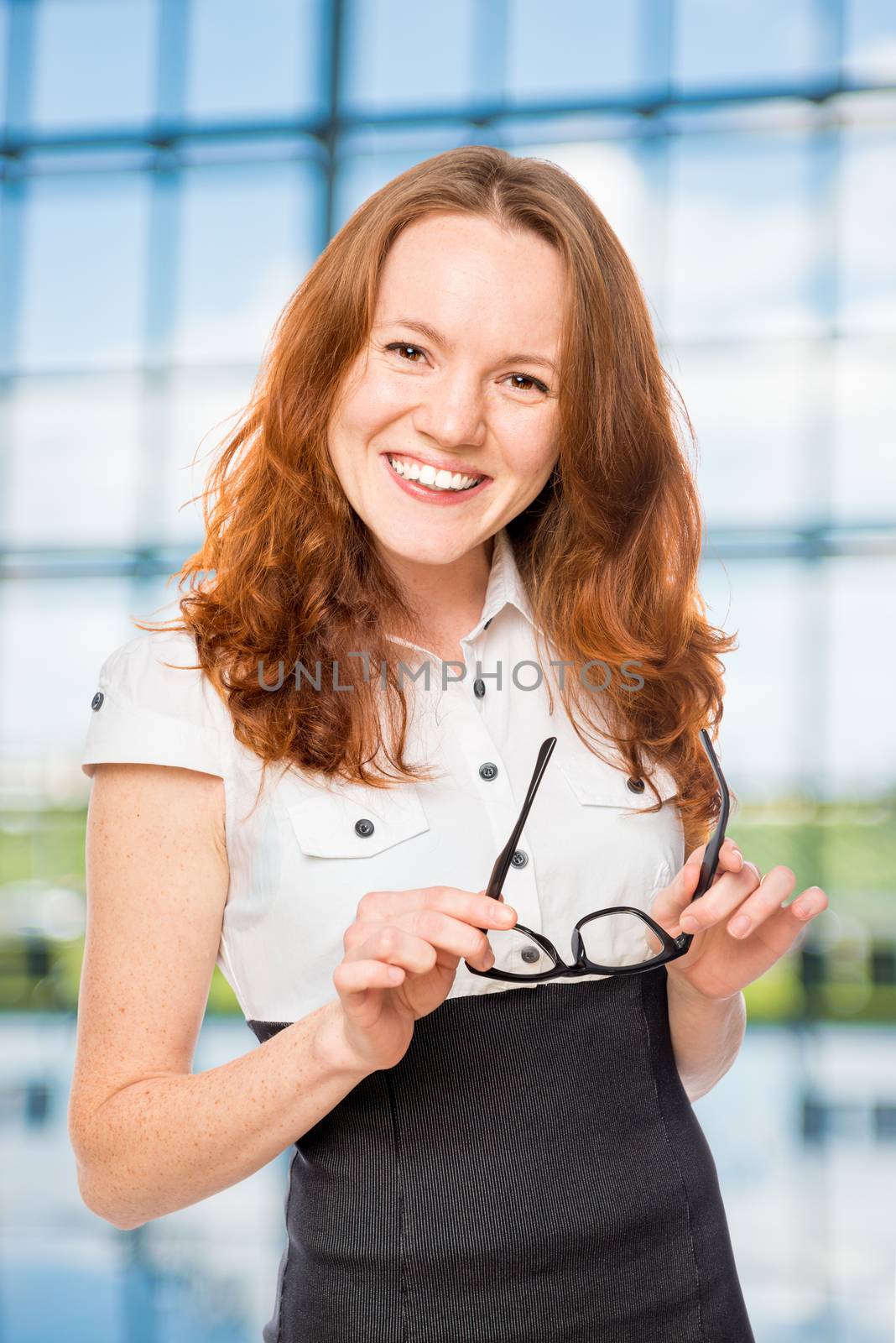 Happy businesswoman with glasses in the office by kosmsos111