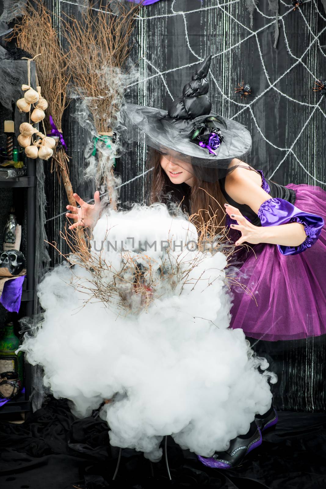 Witch conjures and cooks a love potion in a large cauldron by kosmsos111