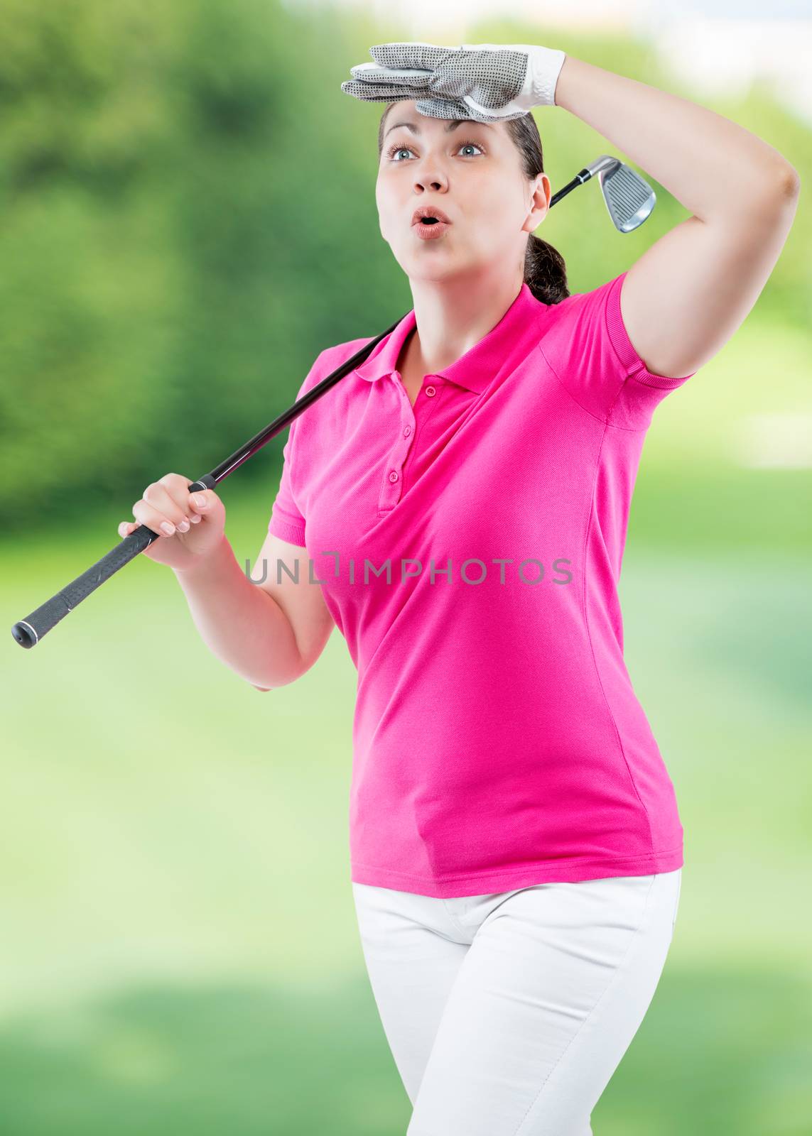 athlete woman watching the ball flight path of golf on a background of golf courses