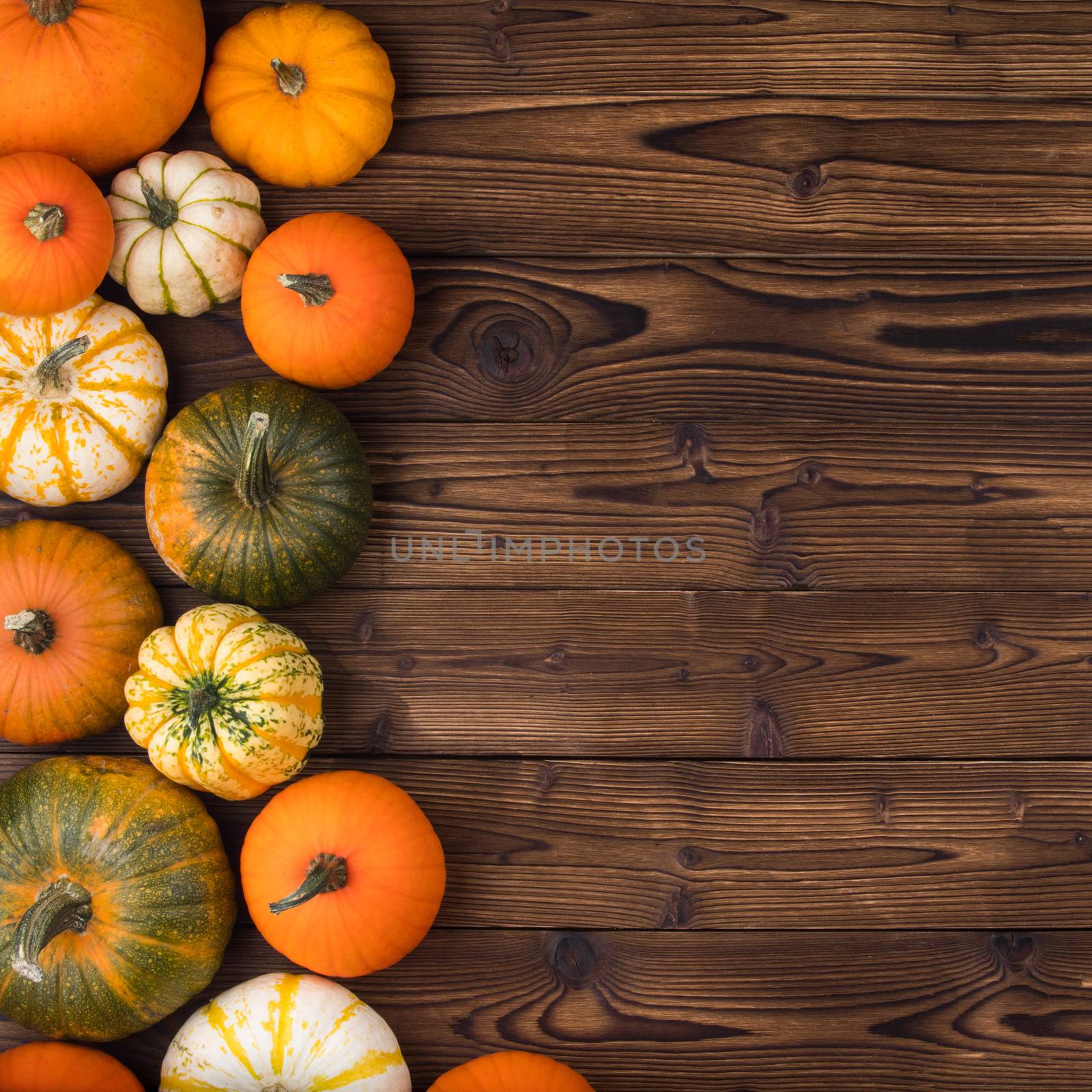 Many orange pumpkins on wooden background, autumn harvest, Halloween or Thanksgiving concept