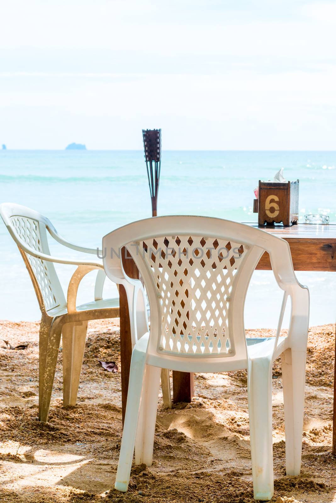 table in a restaurant on the beach in the shade of a tree