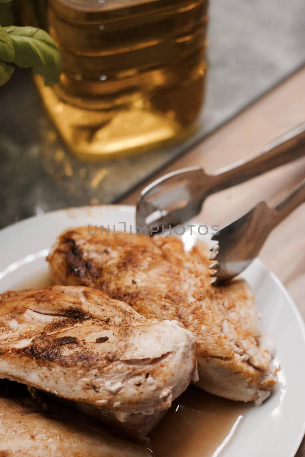 Fresh and delicious grilled chicken on white plate in the kitchen. Food concept.