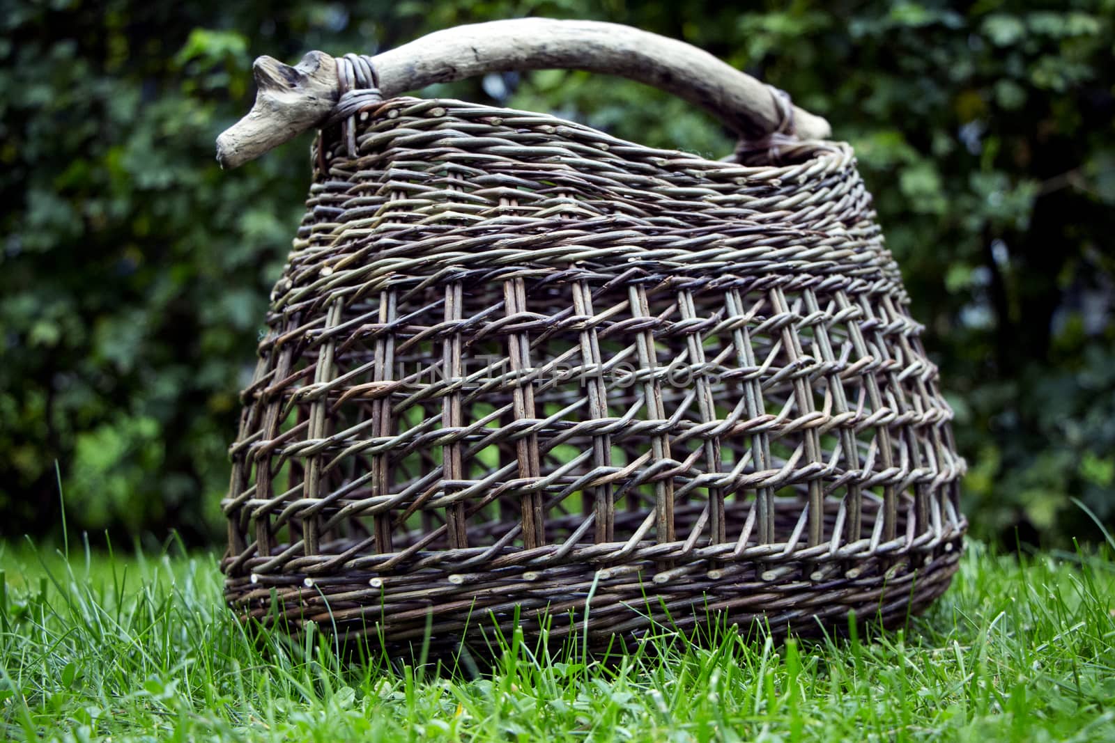 Beautiful basket of wicker with a stick as handle.