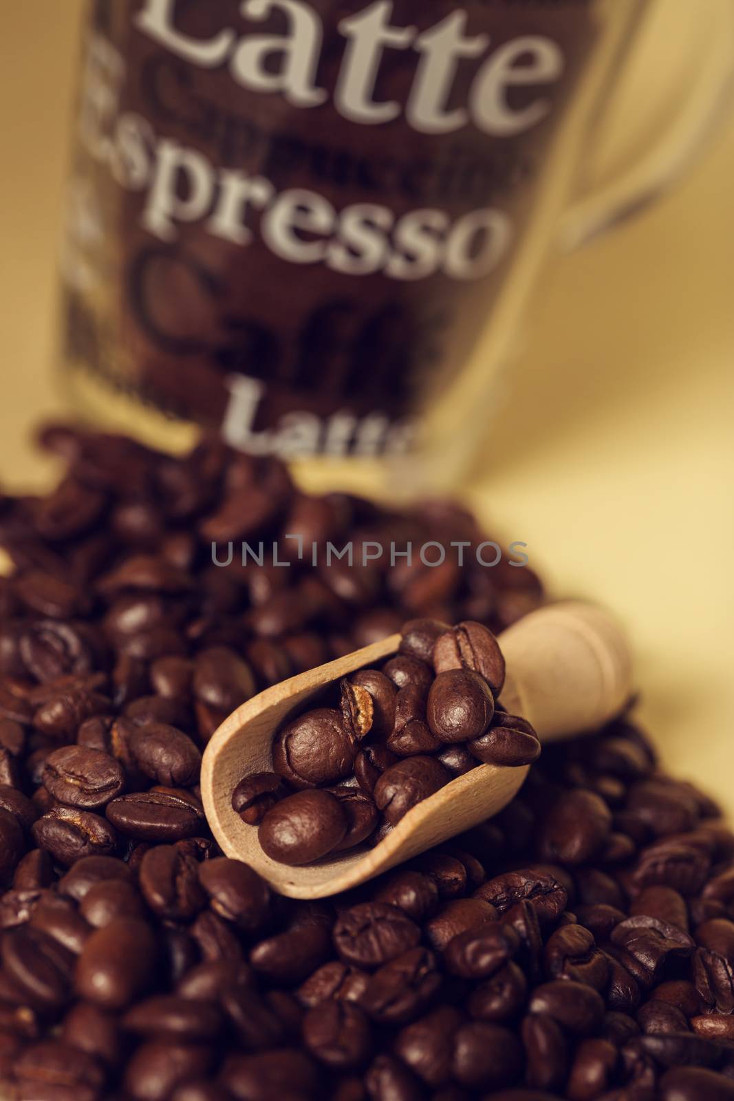 Coffee beans with small measuring spoon made of wood by sandra_fotodesign