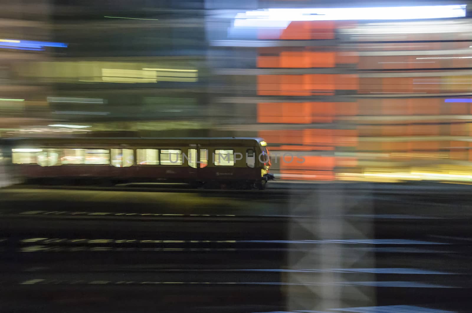 Train accelerating from the station at night, blur to show the speed and movement