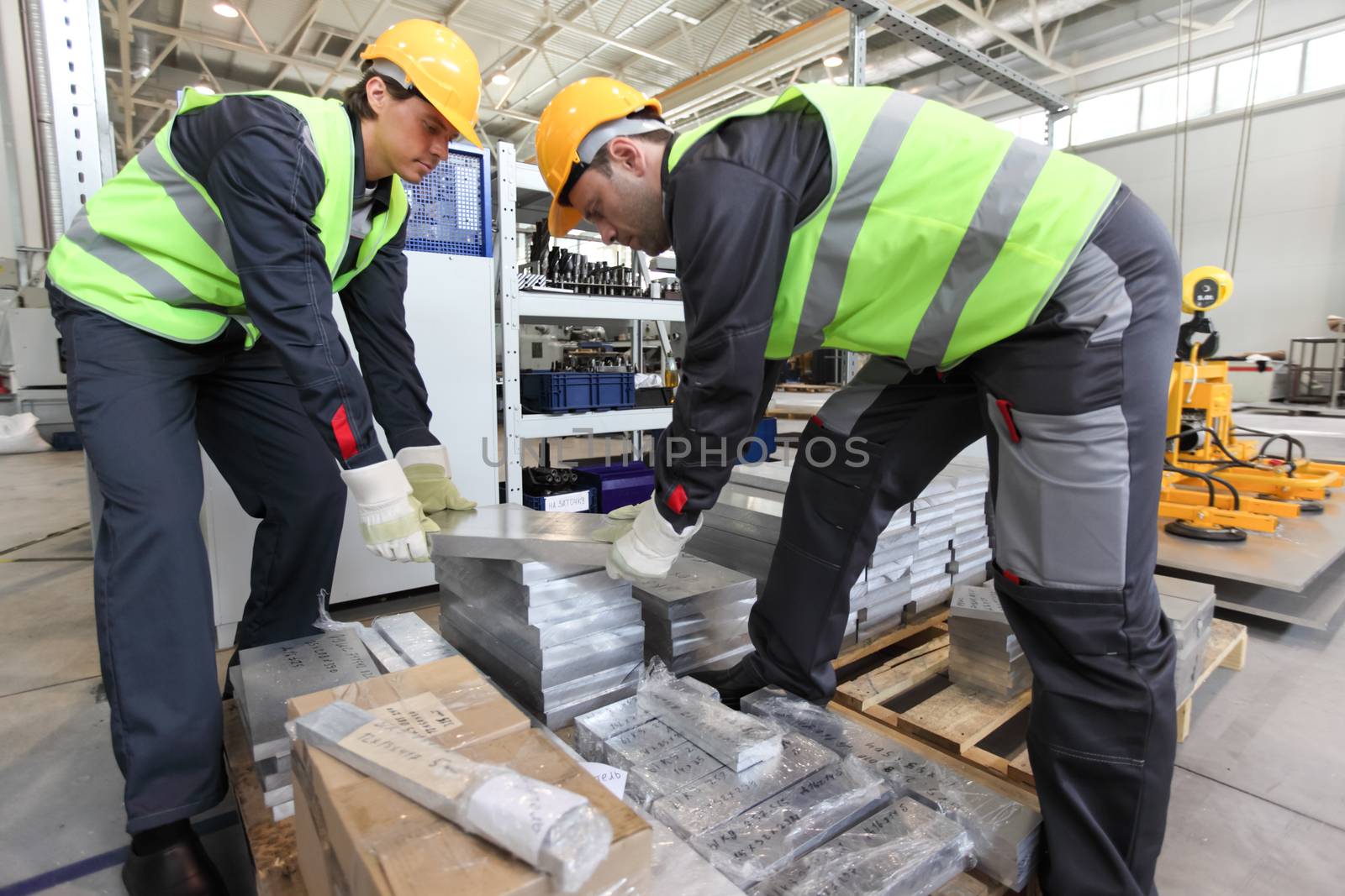 Workers taking aluminium billet at CNC machine shop