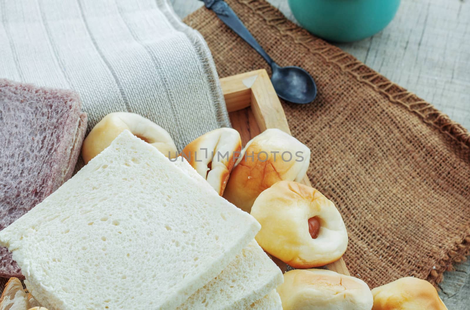 Many breads and cup of coffee on wooden floor.