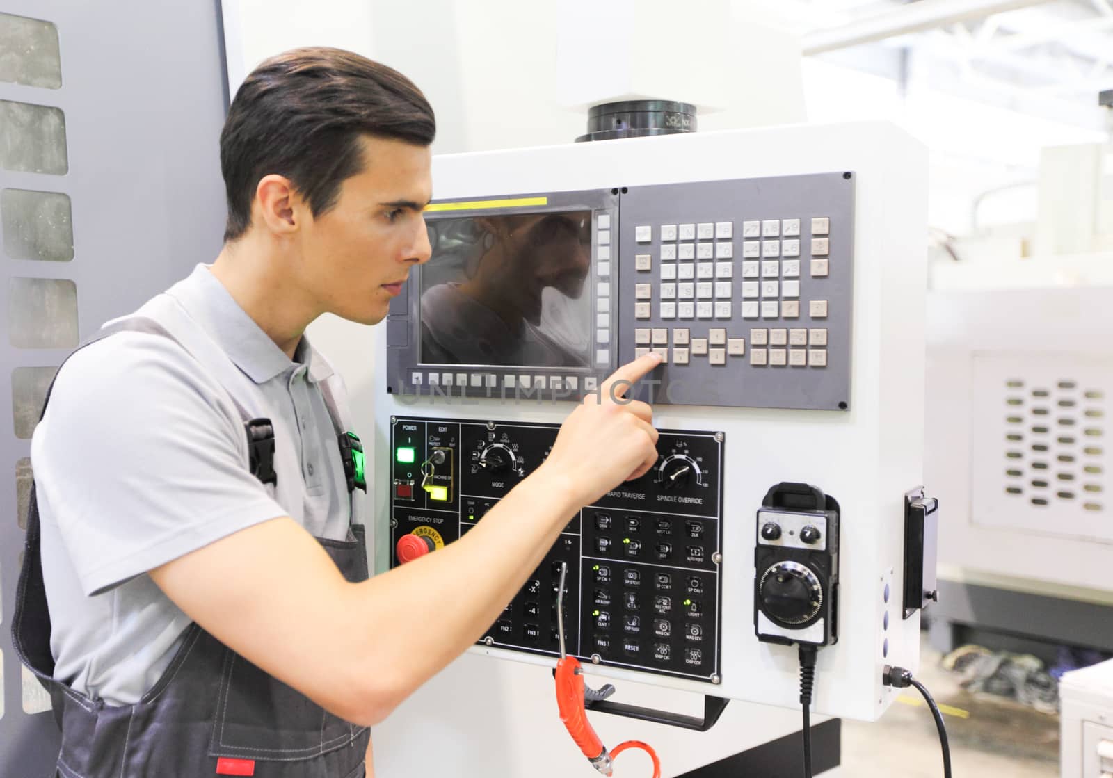 Worker pressing buttons on CNC machine by ALotOfPeople