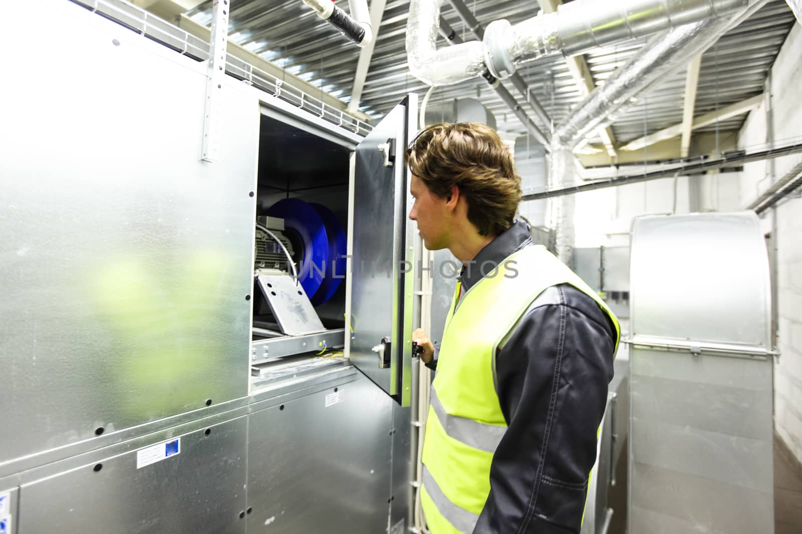 Worker in electrical switchgear room of CNC plant