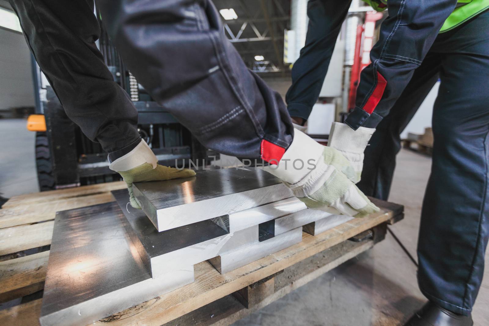 Workers taking aluminium billet at CNC machine shop