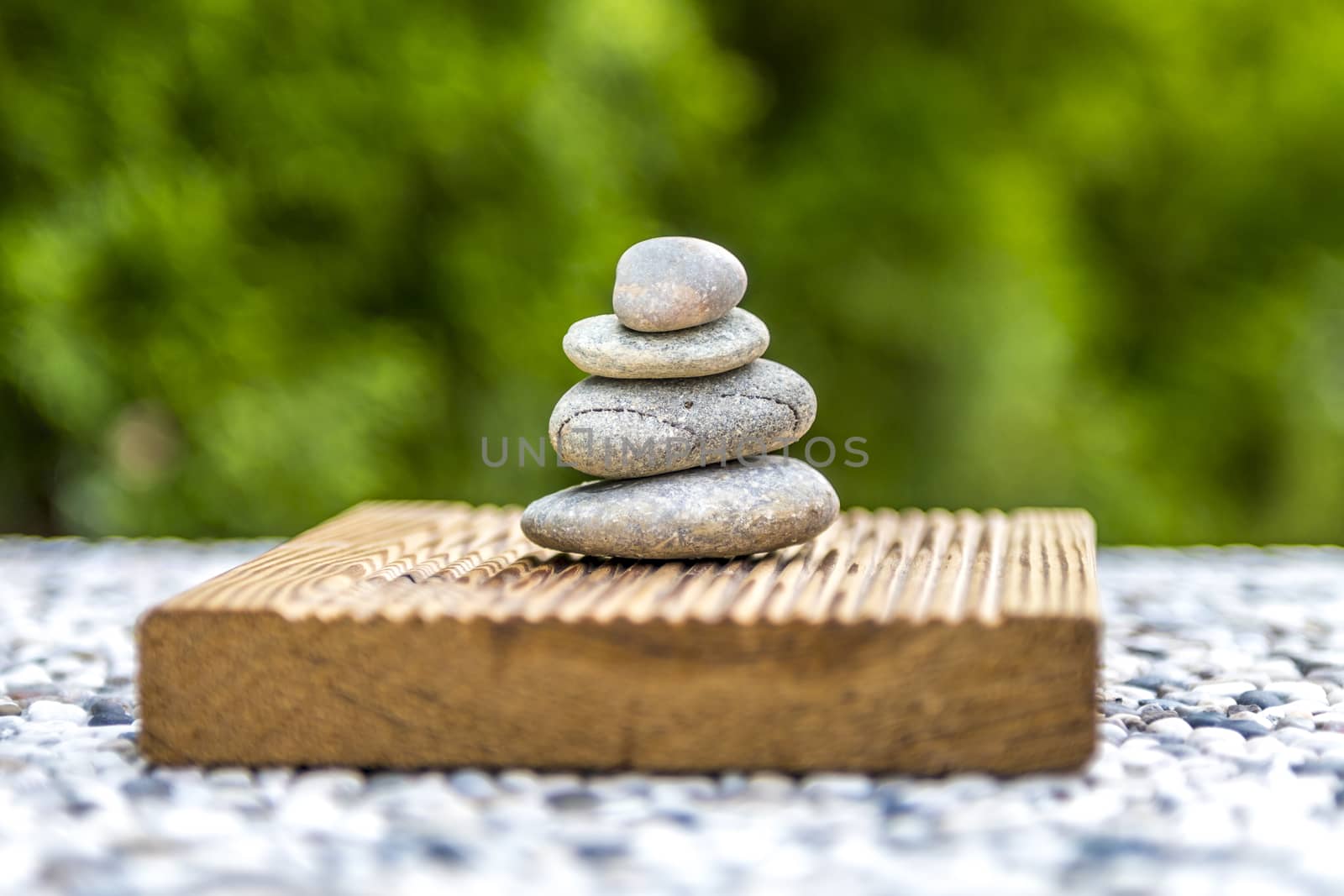 Zen stones on wood with green background