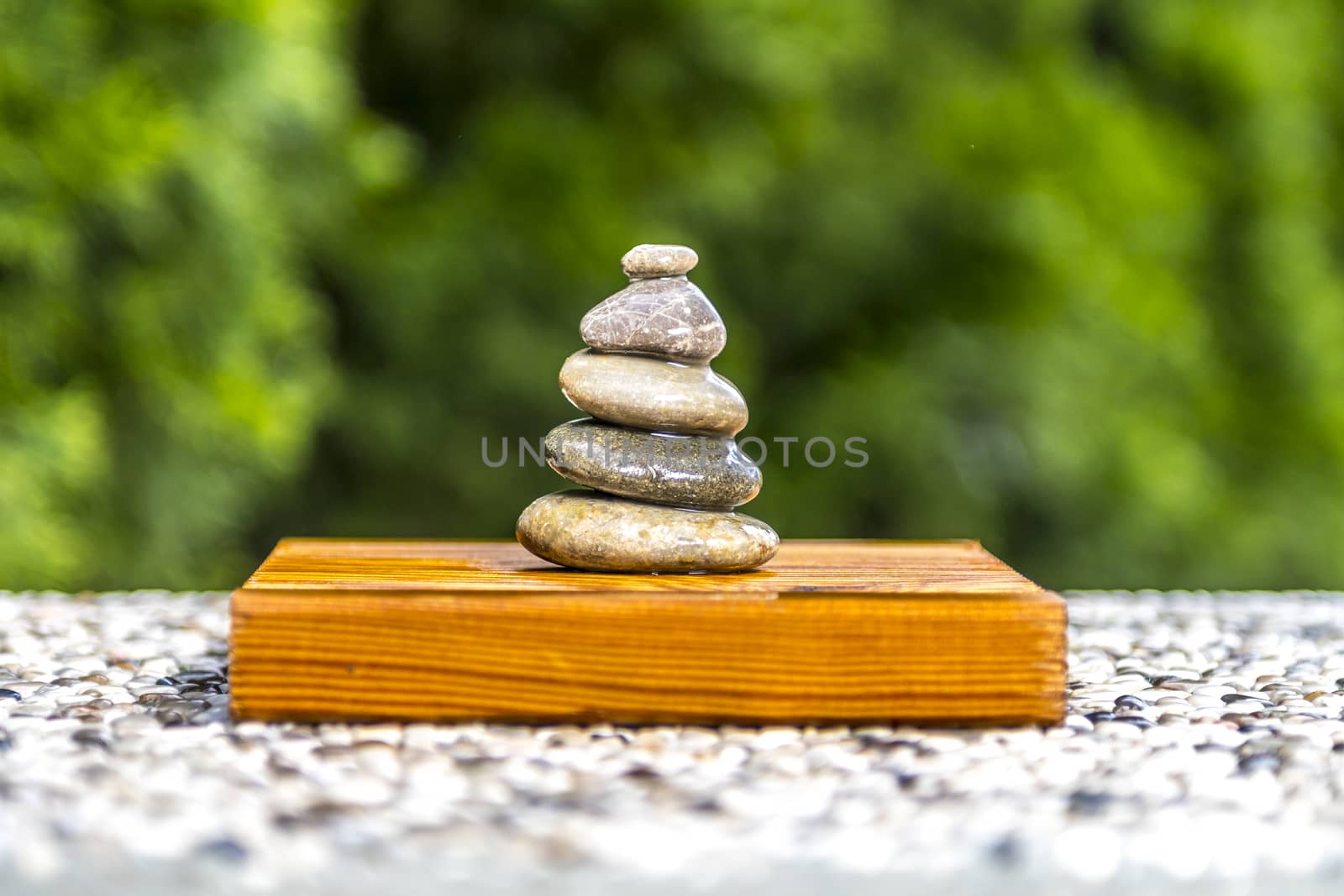 Wet zen stones on wood with green background