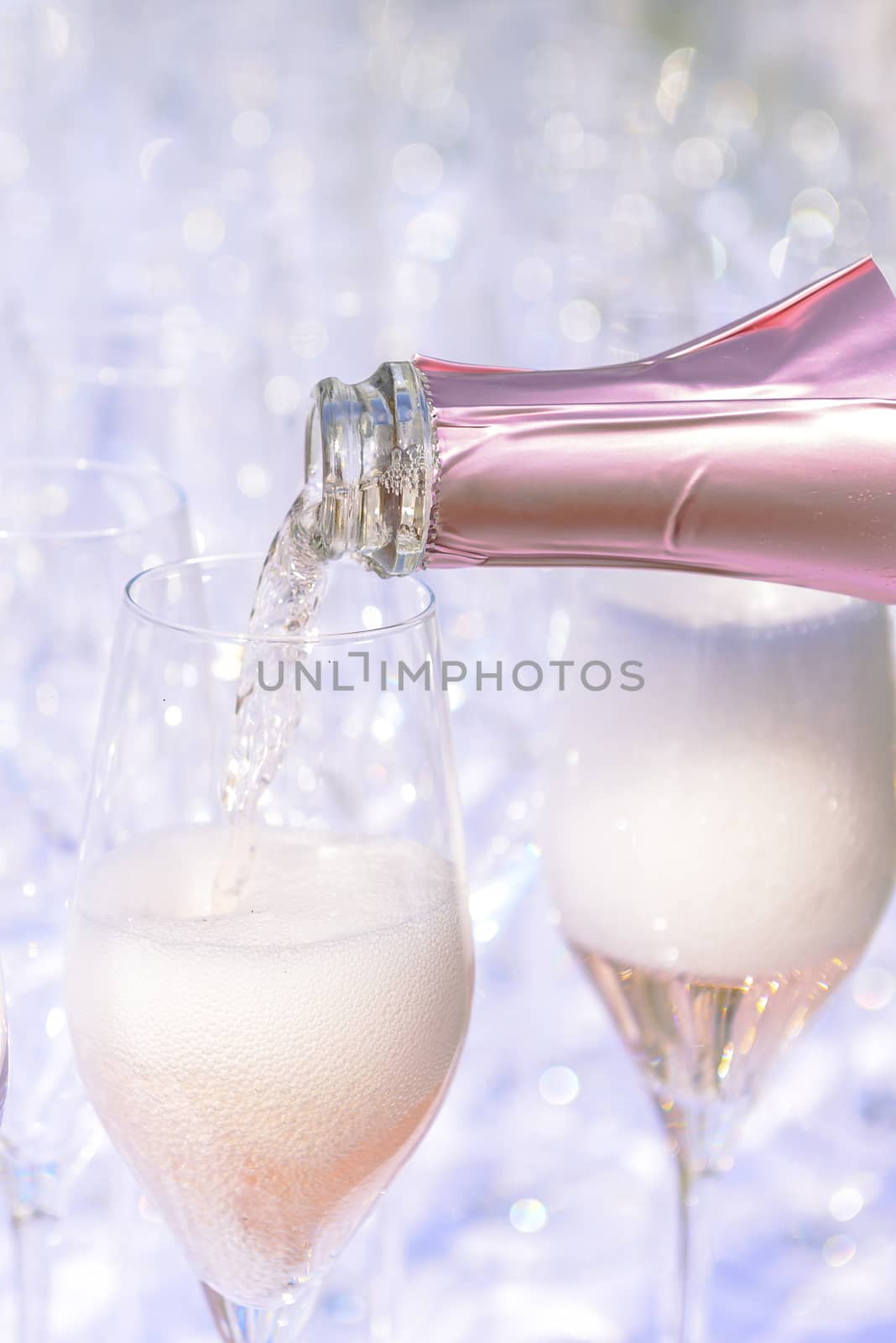 Pouring champagne into glasses by asafaric
