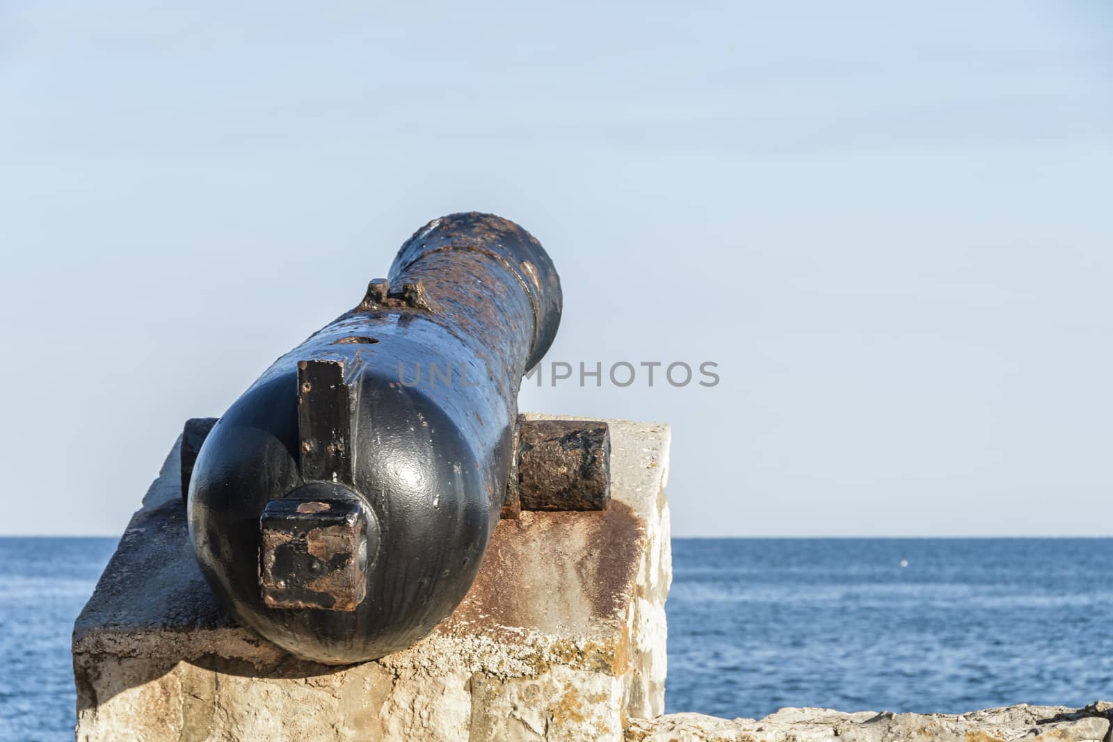 Ancient old cannon on coastal fortress walls by asafaric