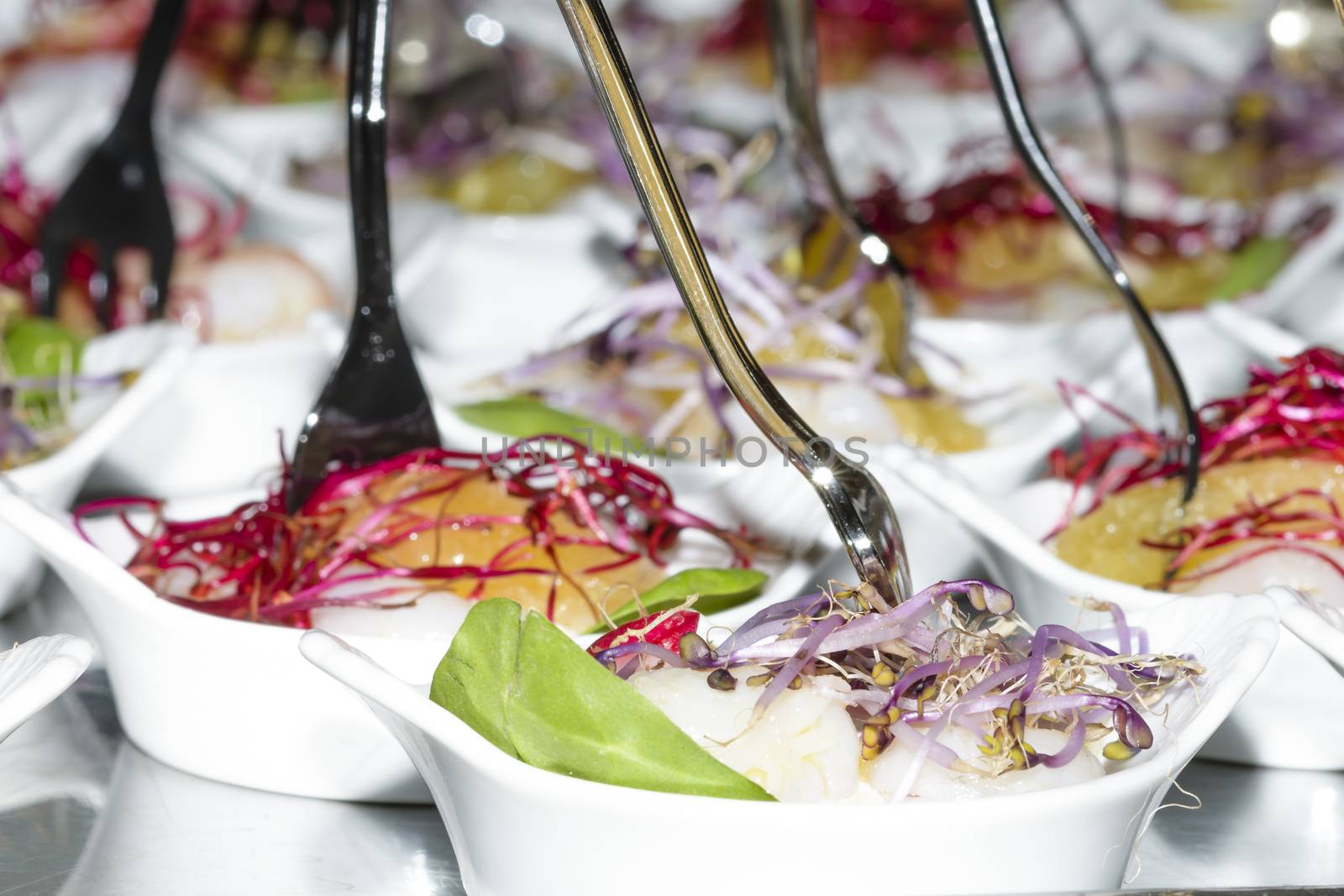 Colorful snacks (appetizers) in white cups with forks on table. Healthy diet or lifestyle concept. Low angle and selective focus. Colorful.