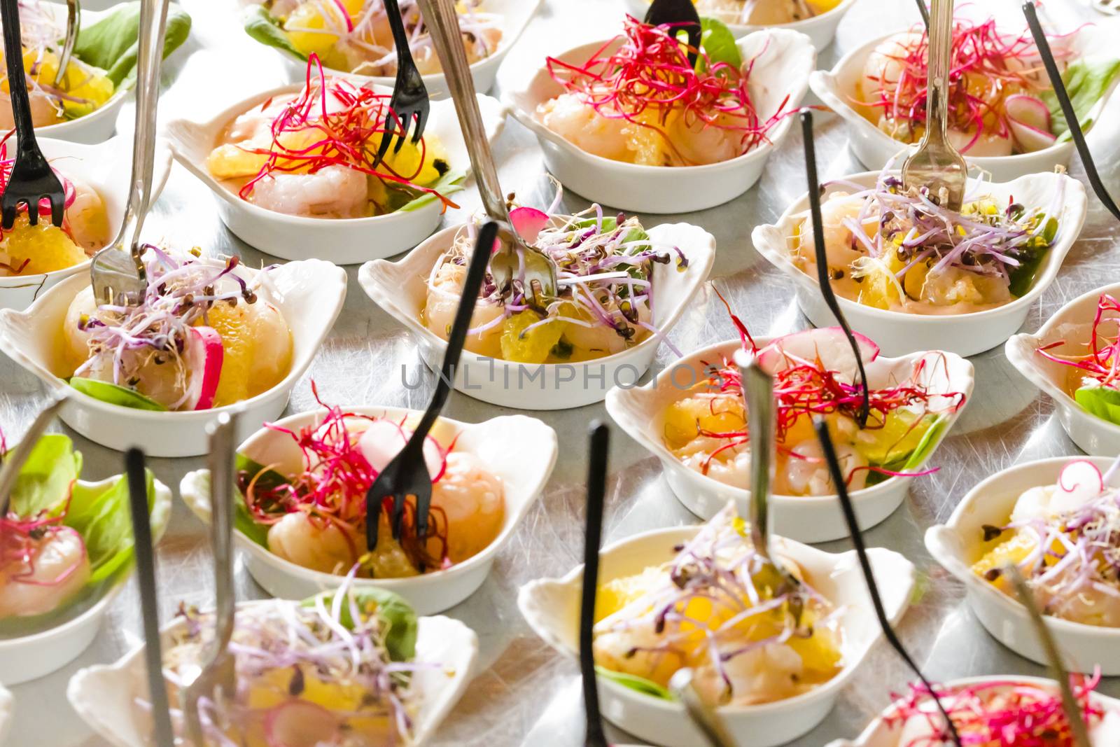 Colorful snacks (appetizers) in white cups with forks on table. Healthy diet or lifestyle concept. Low angle and selective focus. Colorful.