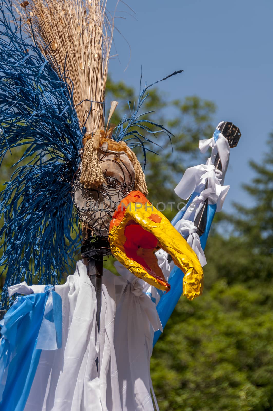 Colorful scarecrow with straw hair, blue, white and yellow