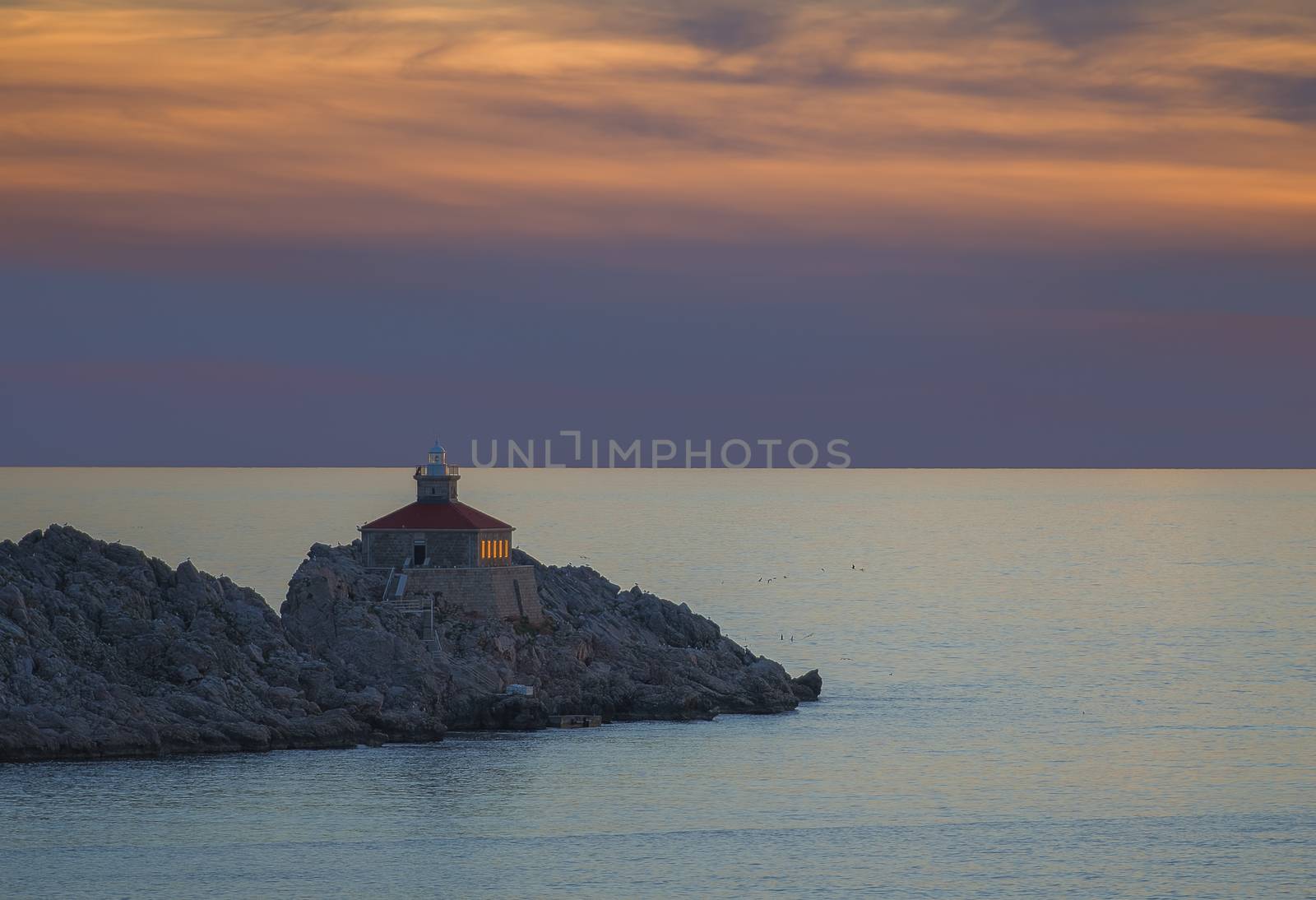 Lighthouse in sunset on island Grebeni, Dubrovnik, Croatia, view from Lapad peninsula