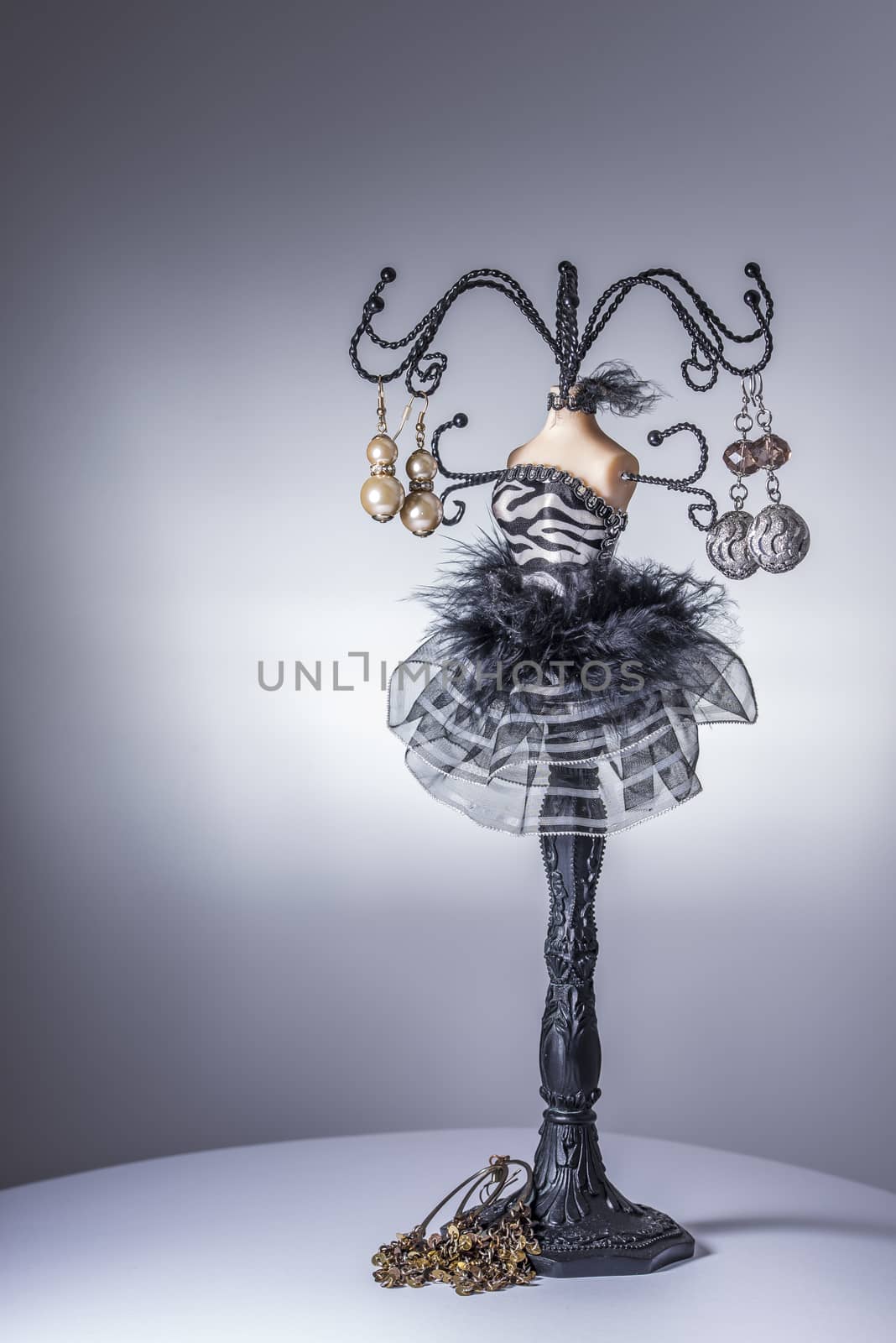 Black jewelery display stand / hanger in form of a woman’s bust in black and white dress with metallic arms as holders