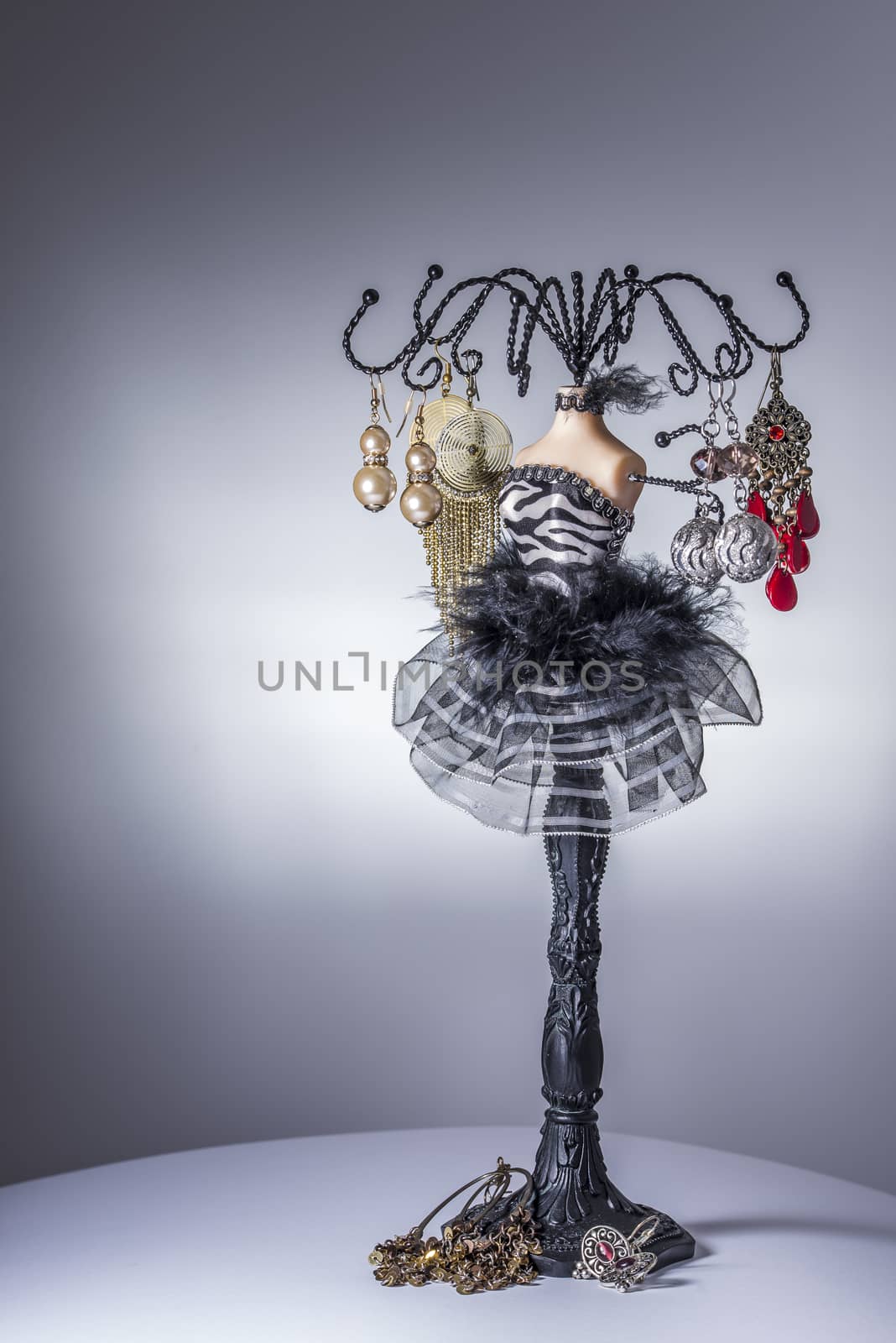 Black jewelery display stand / hanger in form of a woman’s bust in black and white dress with metallic arms as holders