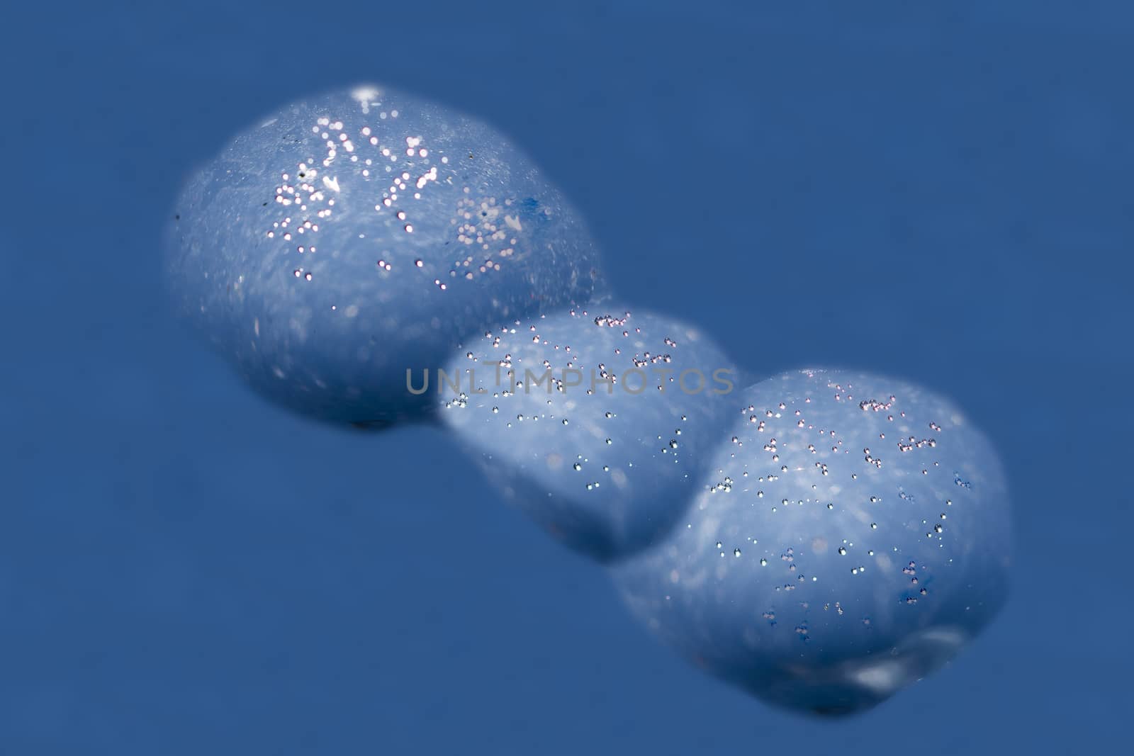 Beautiful micro air bubbles captured in water drops and frozen in ice sparkle in the sun. Closeup macro shot; natural phenomenon