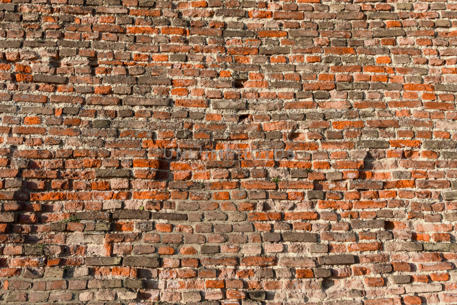 Old red brick wall with signs of wear and tear as background image