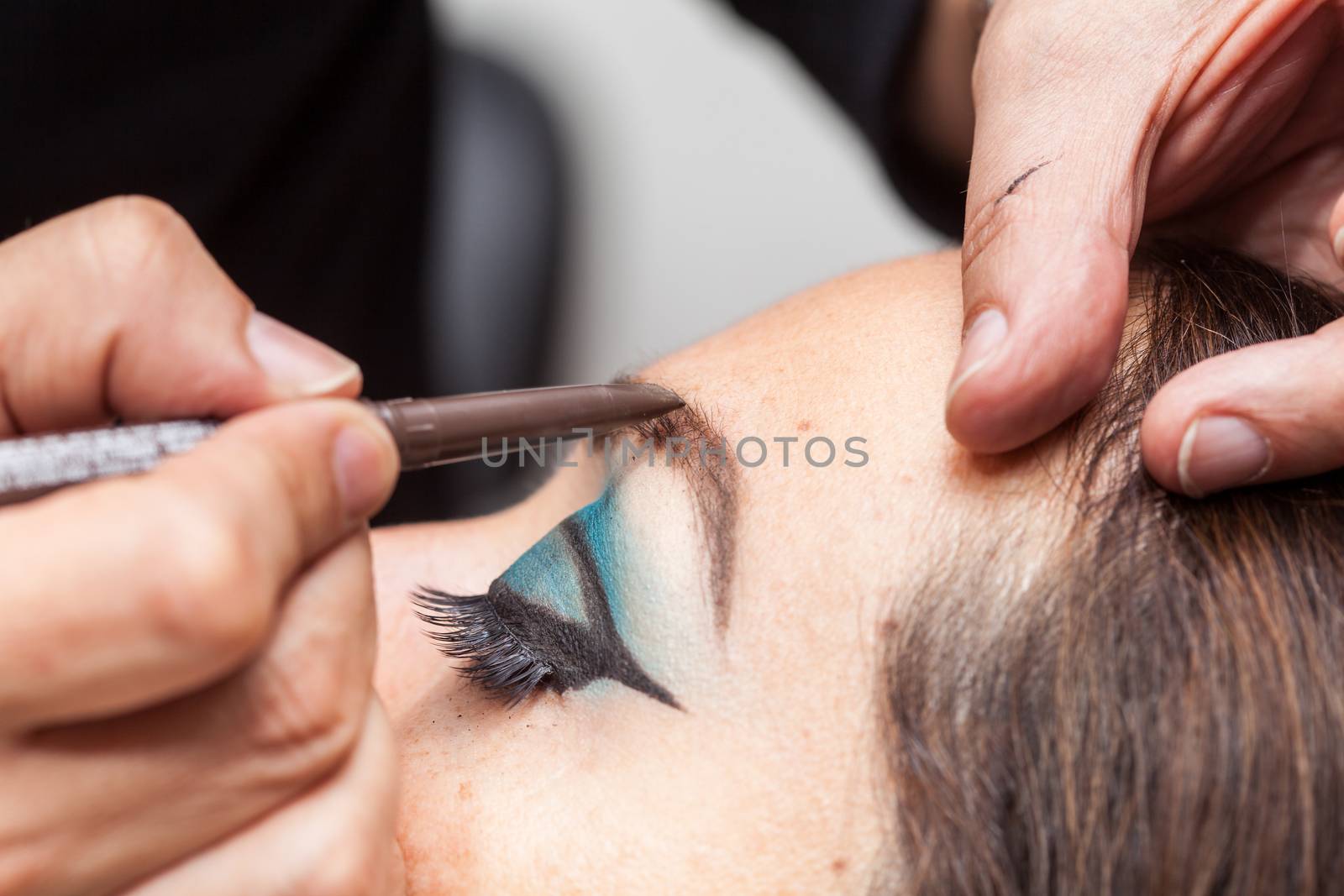 Makeup artist applying makeup on eyebrows