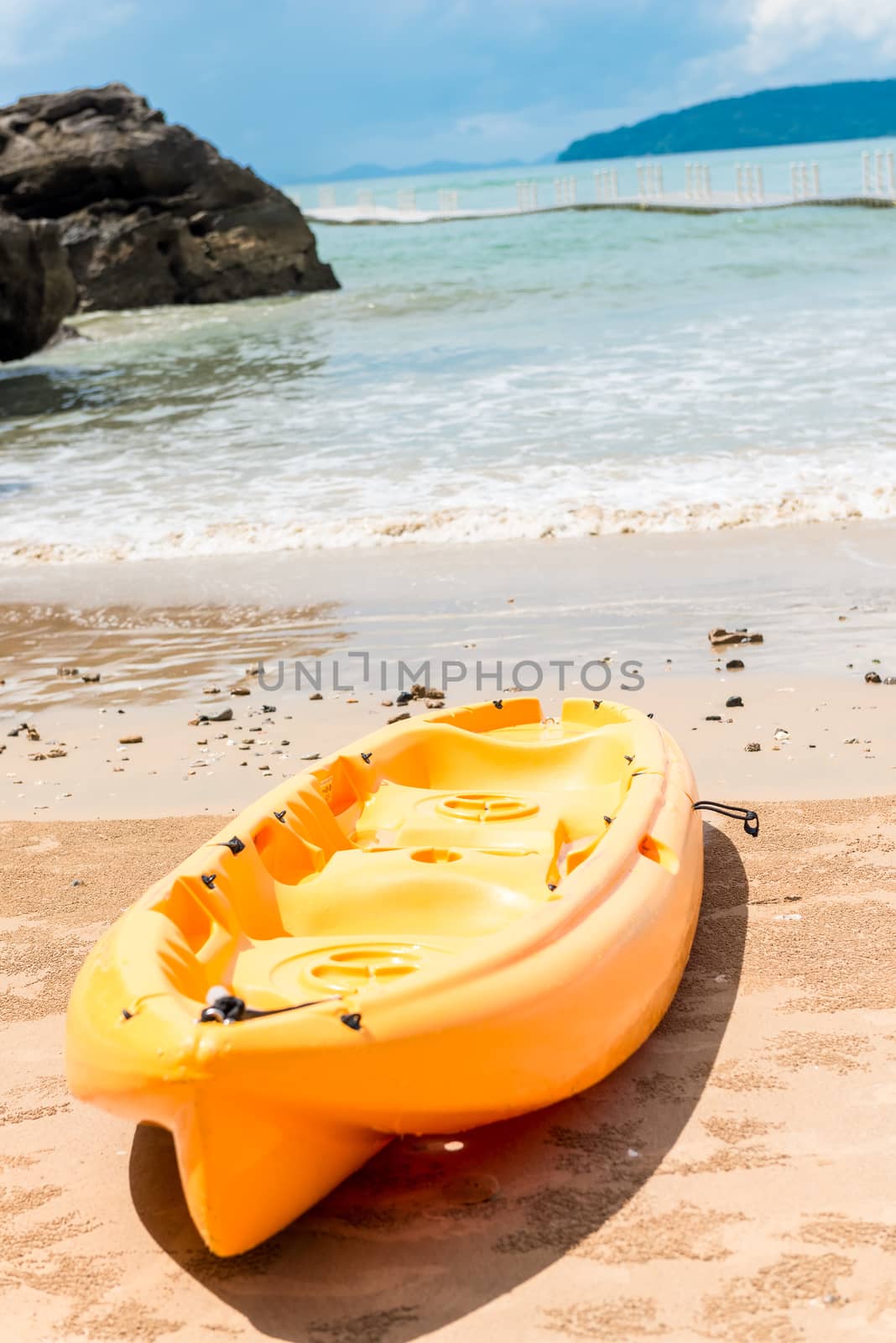 a yellow kayak on the background of the sea lies on the sandy shore