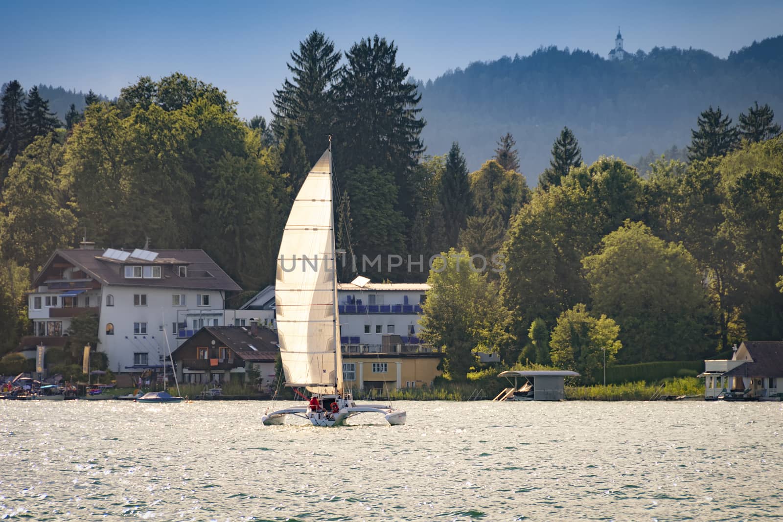 Sailboat - trimaran on lake Worthersee in Austria at sunset