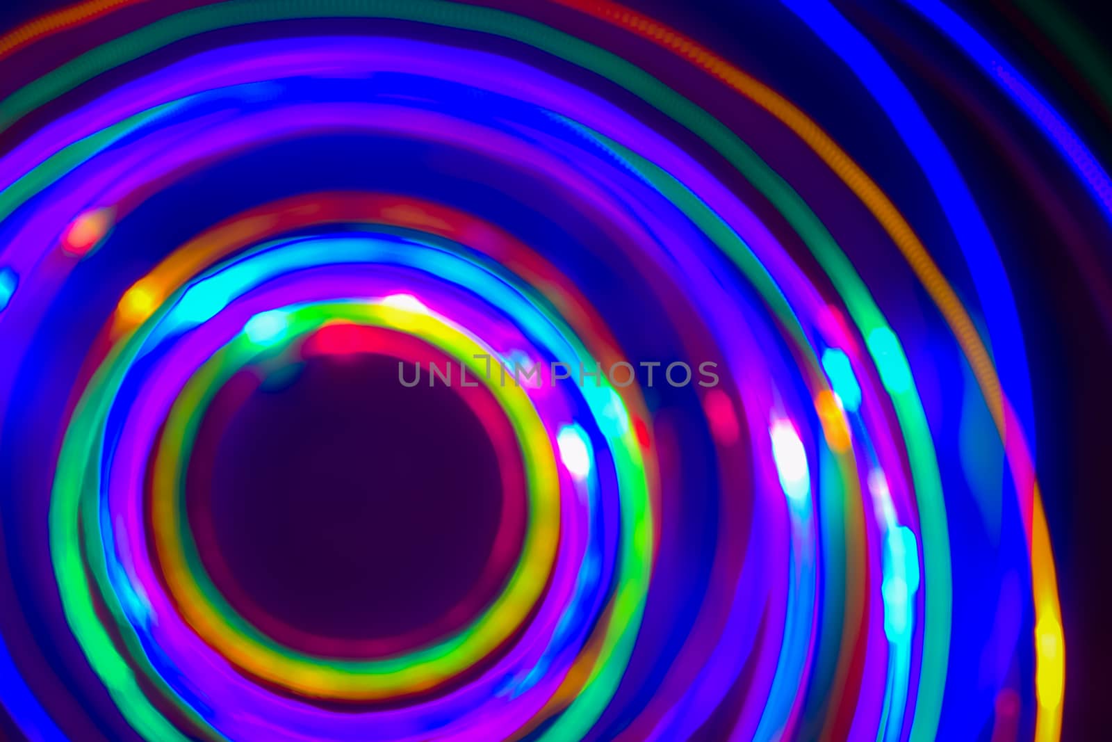 Christmas tree lights spun around to achieve a spiral glowing effect; abstract circular color trails, defocused, abstract