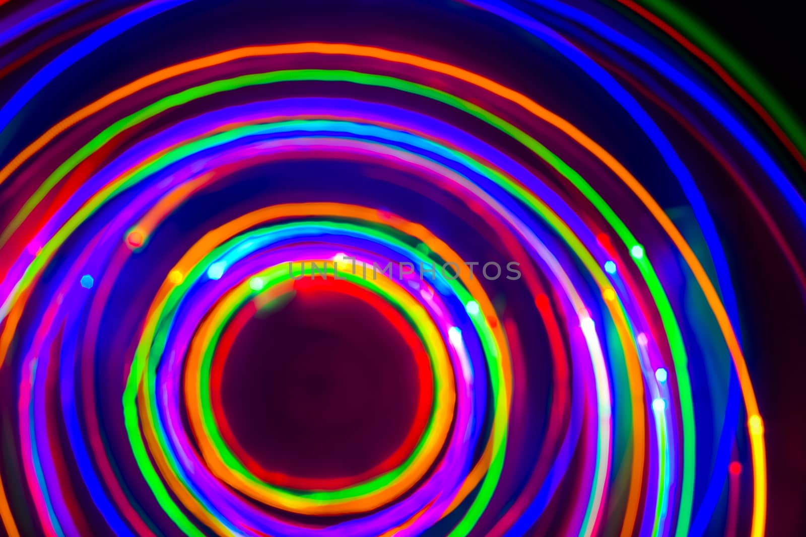 Christmas tree lights spun around to achieve a spiral glowing effect; abstract circular color trails, defocused, abstract