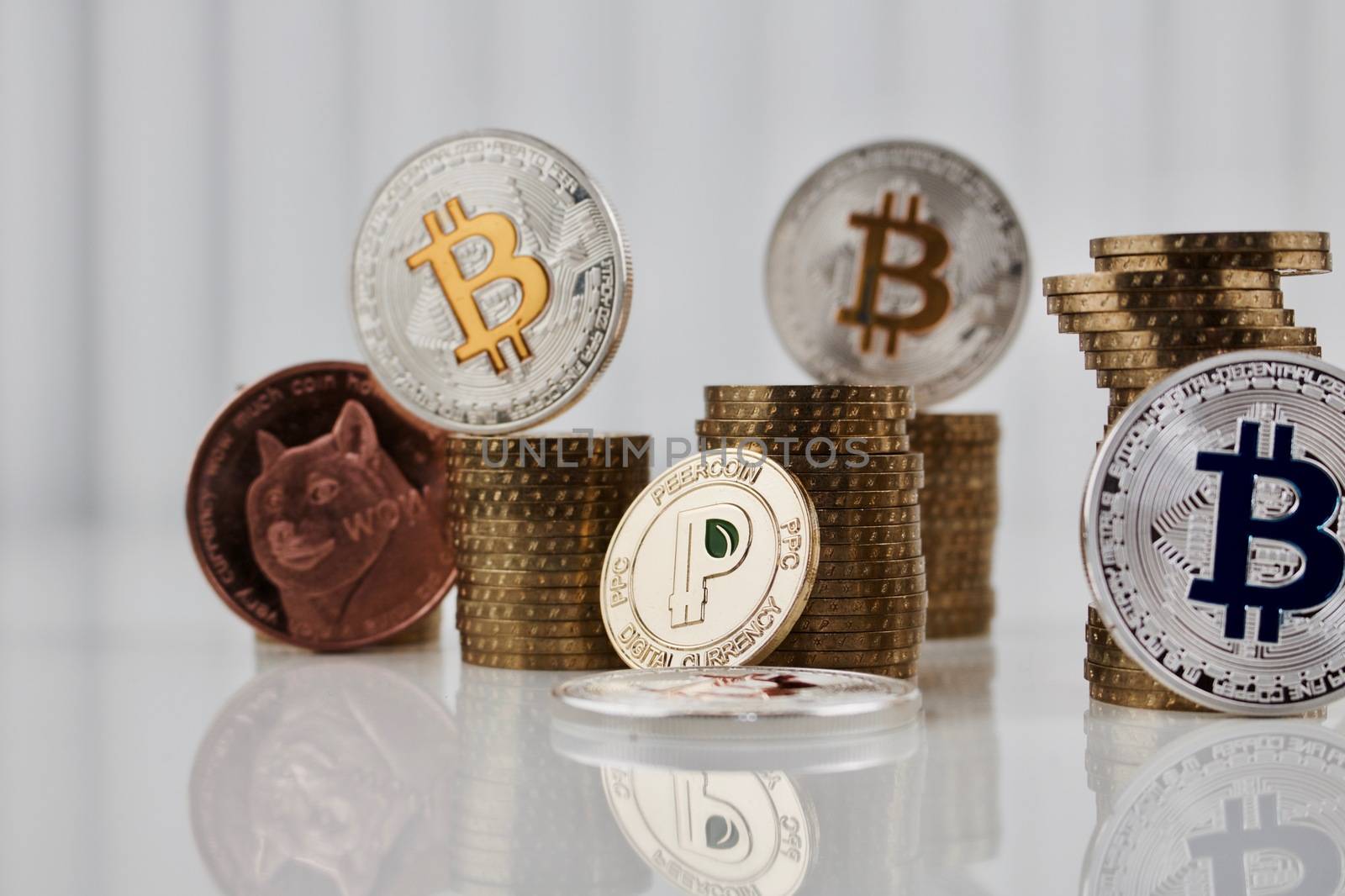 Digital currency physical gold peercooin coin near dogecoin and bitcoins.