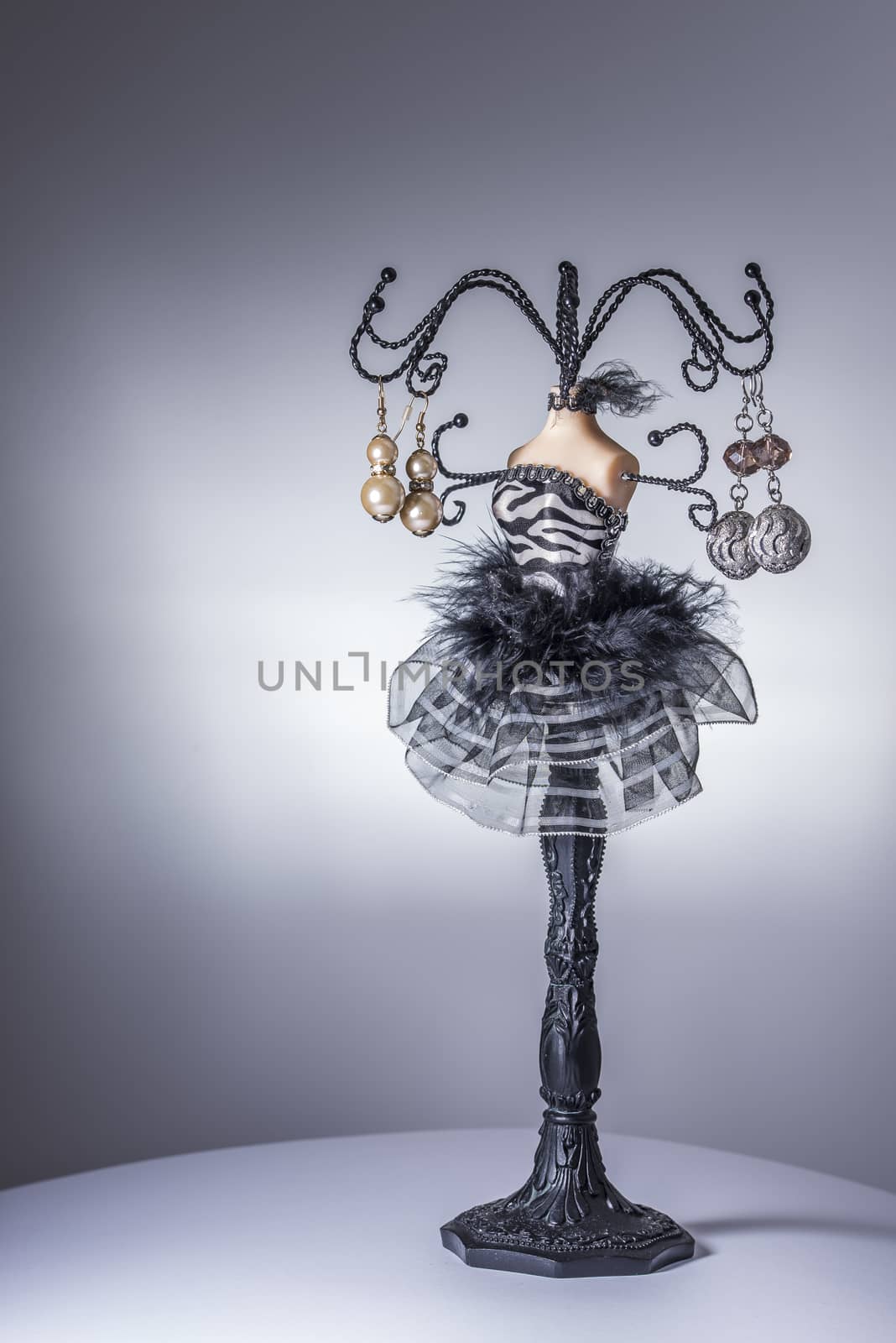 Black jewelery display stand / hanger in form of a woman’s bust in black and white dress with metallic arms as holders