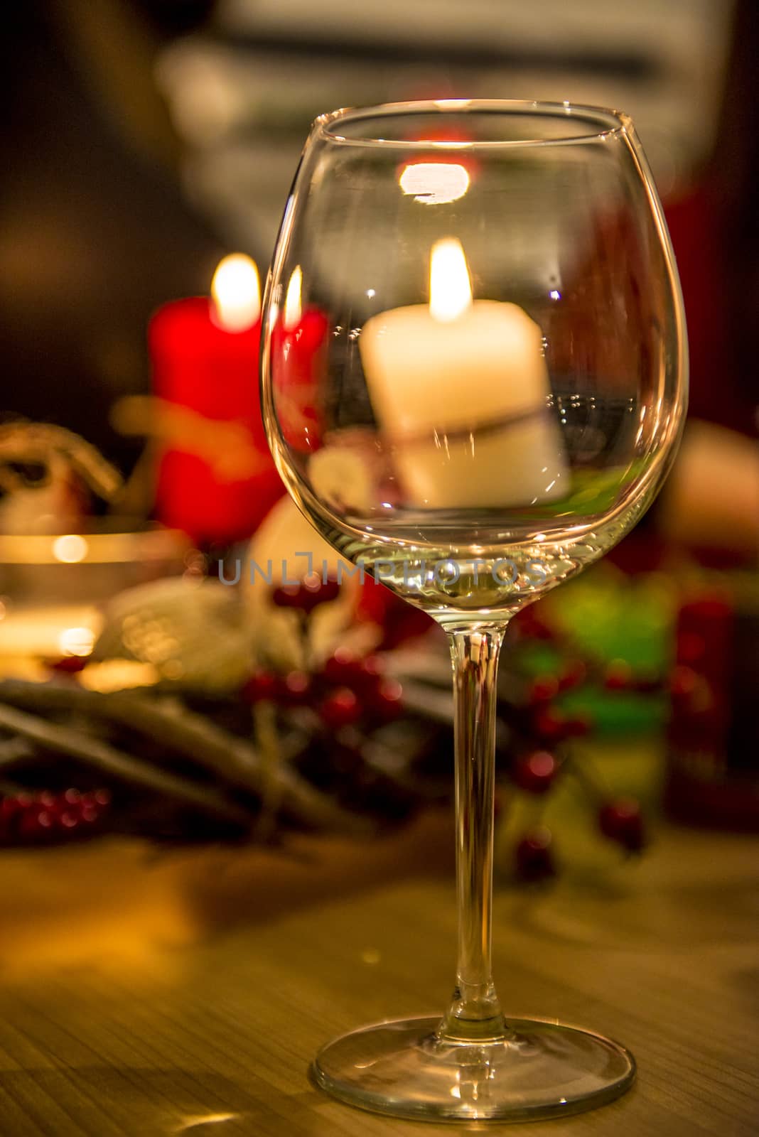 Empty glass in front of candles, xmas decoration