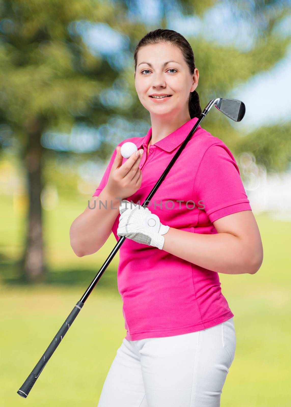 young professional golfer posing on a background of golf courses